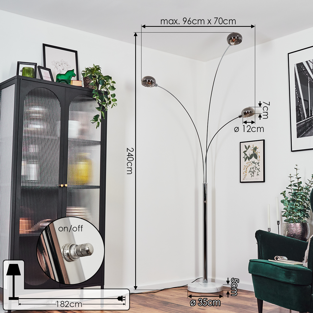 Eine moderne Stehlampe mit drei kugelförmigen Schirmen. Ein schwarzer Schrank und ein grüner Stuhl sind im Hintergrund.