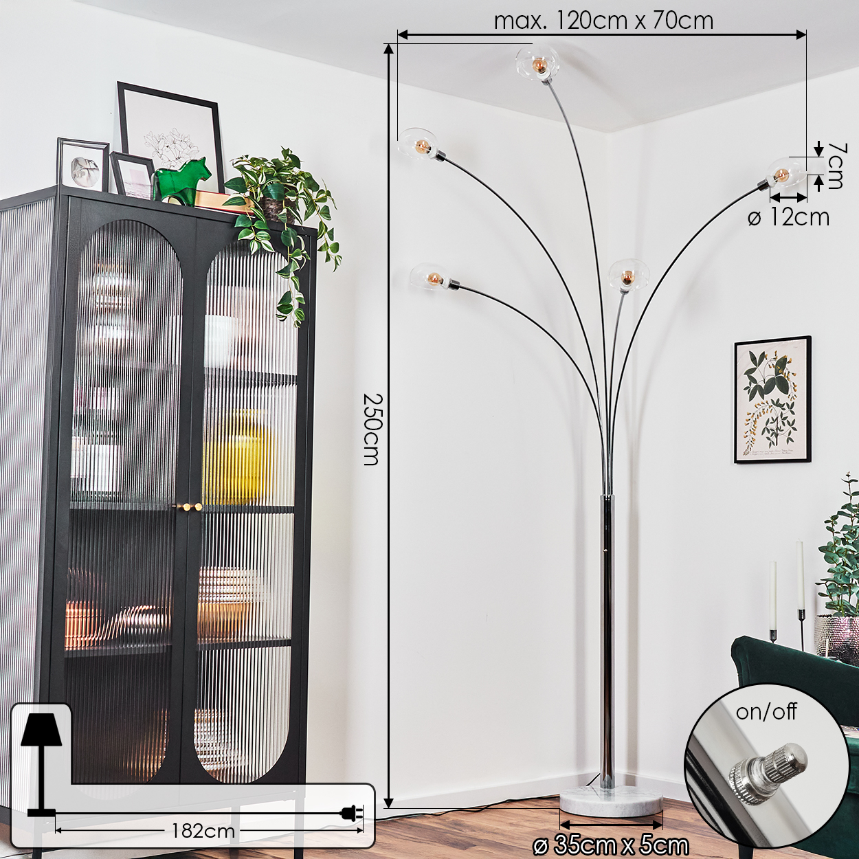 Eine moderne Stehlampe mit fünf Glühbirnen steht in einer Ecke. Ein schwarzer Schrank und grüne Pflanzen sind im Hintergrund.