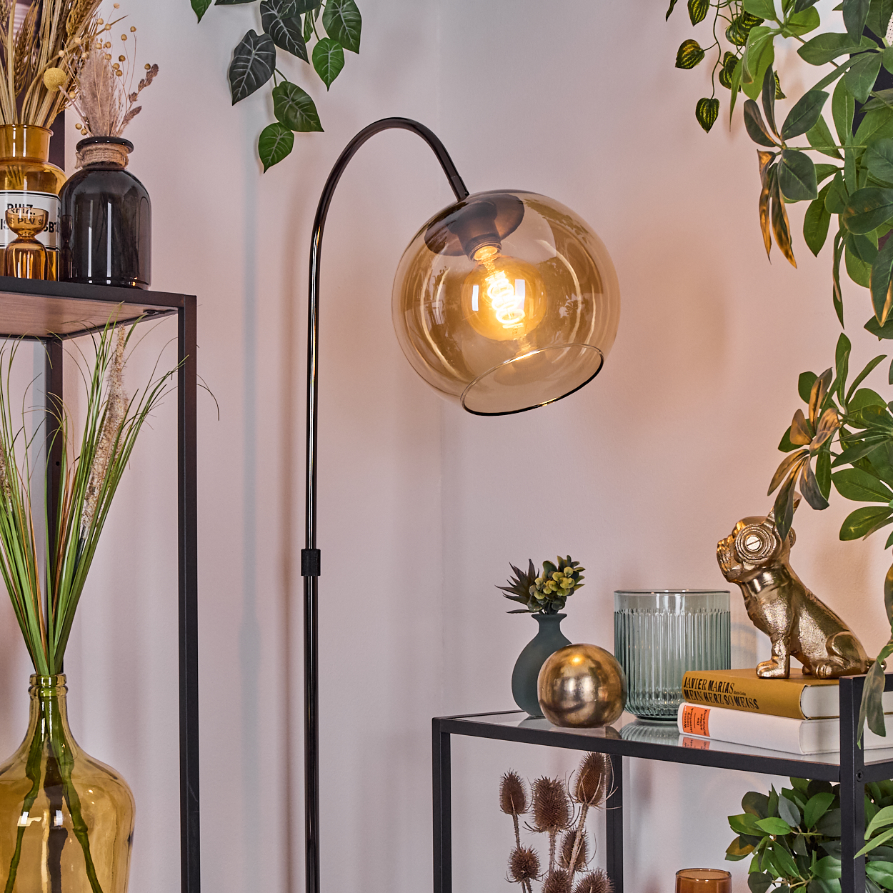 Moderne Wohnzimmerszene. Eine schwarze Stehlampe mit bernsteinfarbenem Glasschirm beleuchtet. Regale zeigen Vasen und Dekoration.