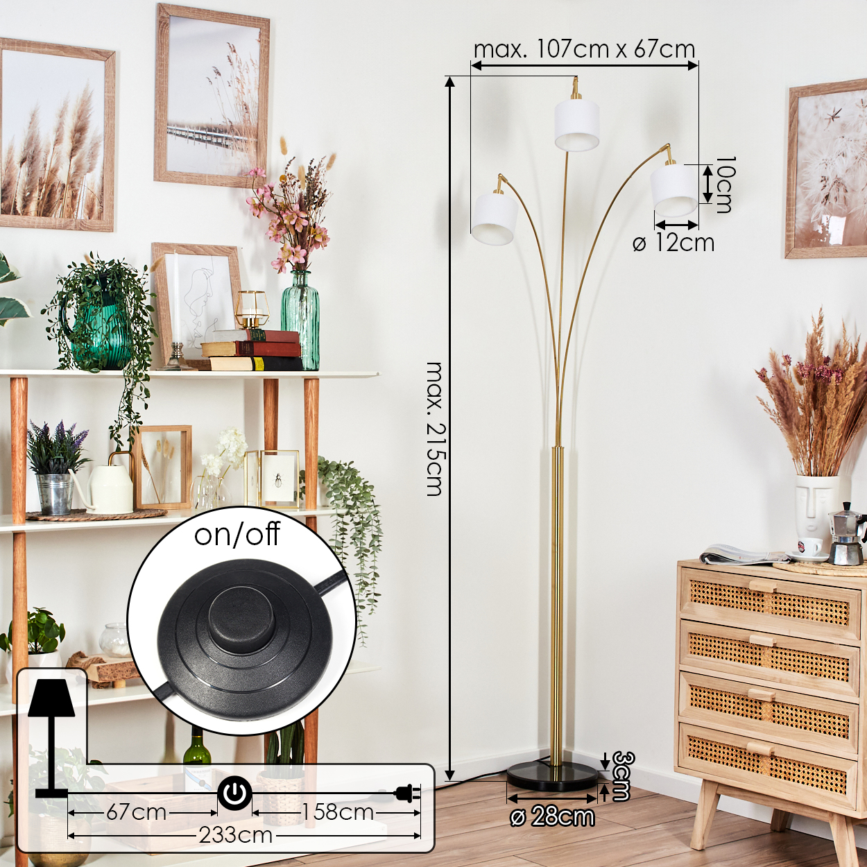Eine goldene Stehlampe mit drei weißen Lampenschirmen. Sie steht neben einem Holzschrank mit Dekorationsartikeln. Eine weiße Wand ist der Hintergrund.