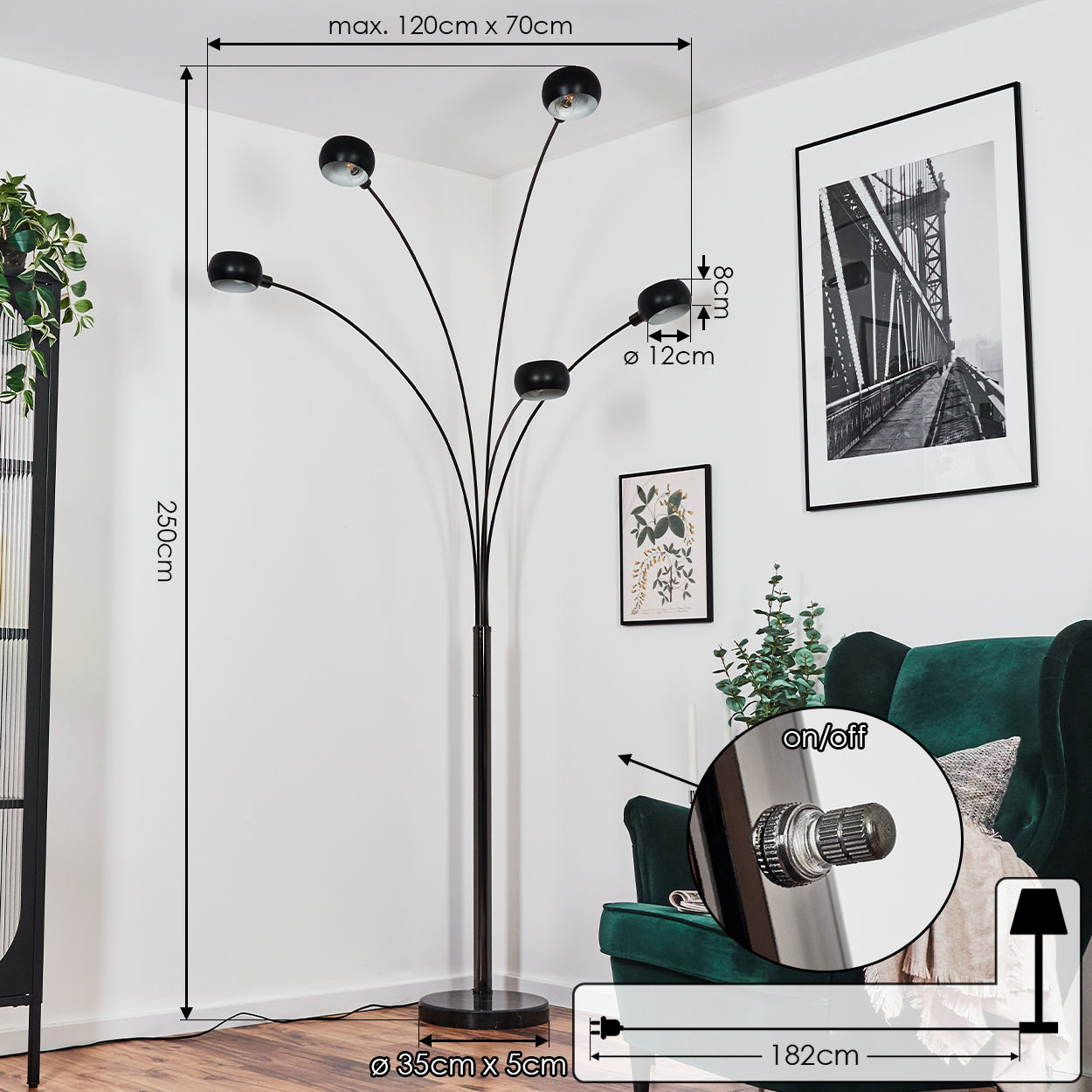 Eine moderne schwarze Stehlampe mit fünf Lichtern. Sie steht in der Nähe eines grünen Sessels und eines gerahmten Brückenfotos. Die Wand ist weiß.
