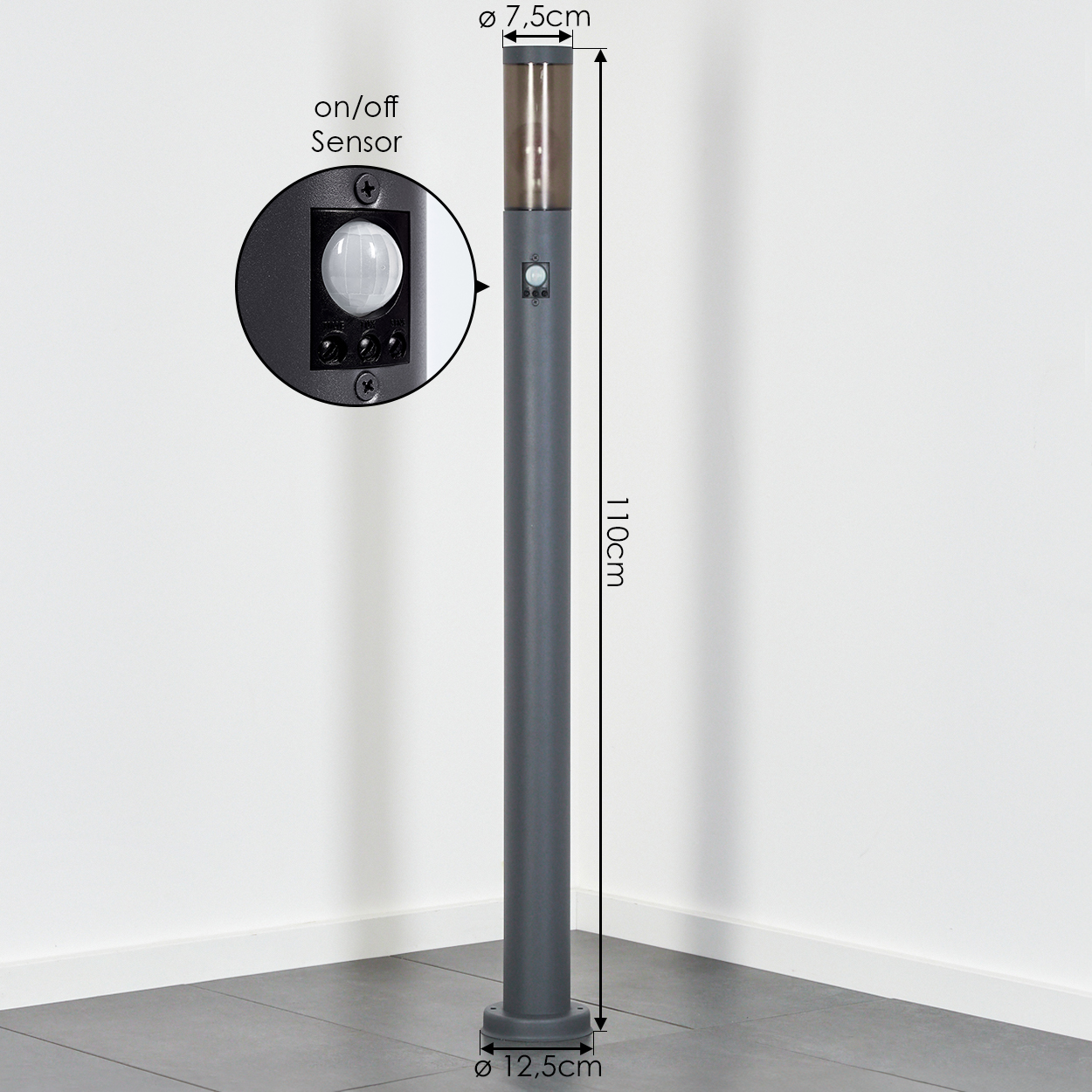 Graue Außenlampe vor weißer Wand. Die Lampe hat einen Sensor und einen Ein/Aus-Knopf. Maße sind angegeben.