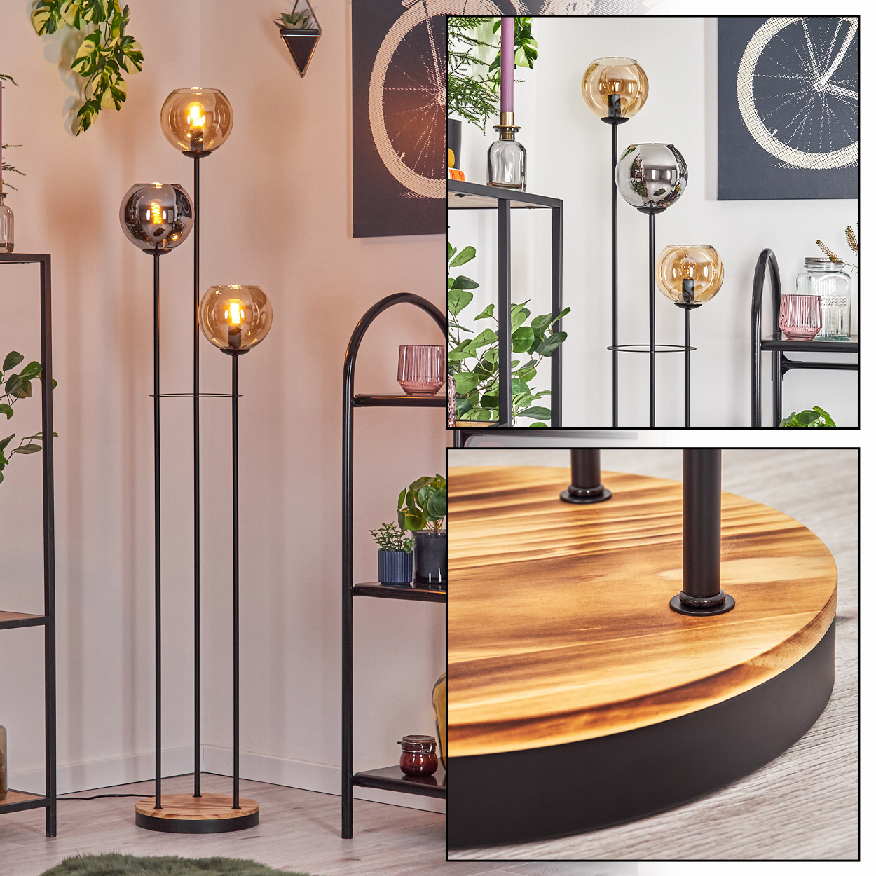 Eine Stehlampe mit drei Glaskugeln. Die Lampe ist schwarz mit einem Holzsockel. Regale, Pflanzen und Kunst sind im Hintergrund.