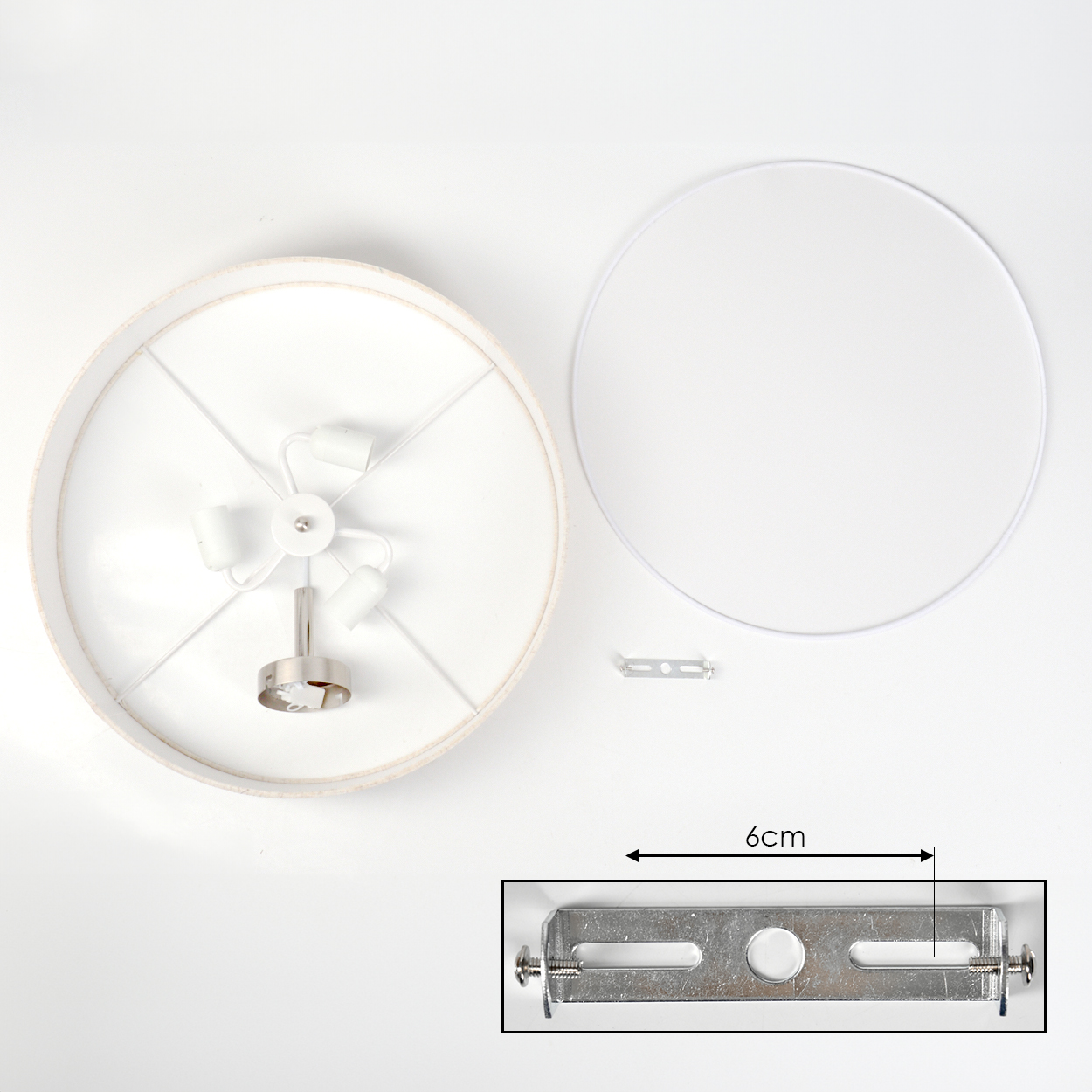 Draufsicht auf eine zerlegte Lampe. Die Teile umfassen einen Lampenschirm, einen Rahmen, eine Metallhalterung und eine Lampenfassung, alles auf weißem Untergrund.
