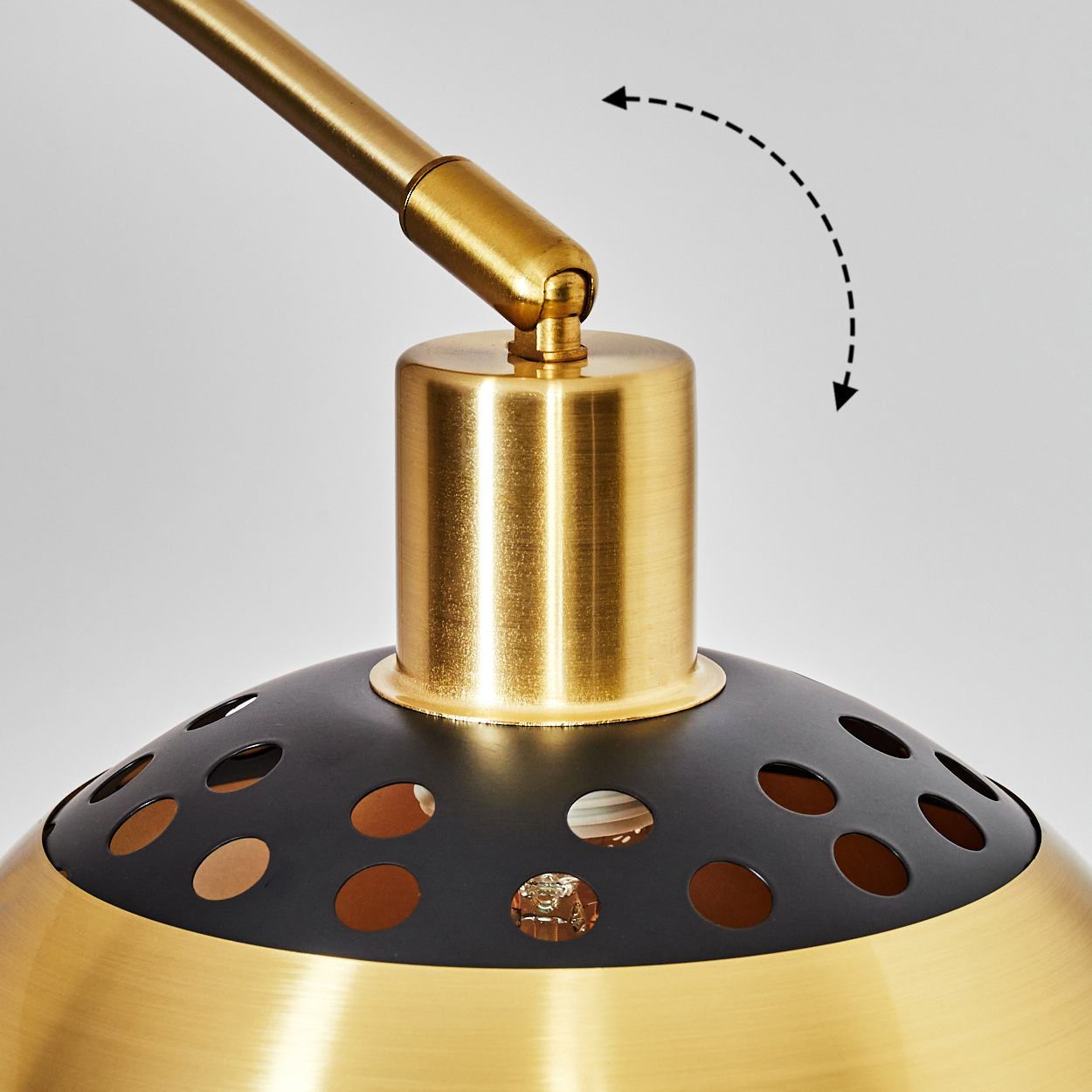 Nahaufnahme einer gold-schwarzen Lampe. Die Lampe hat einen zylindrischen Sockel und einen perforierten Schirm. Ein Pfeil zeigt die Verstellbarkeit an.