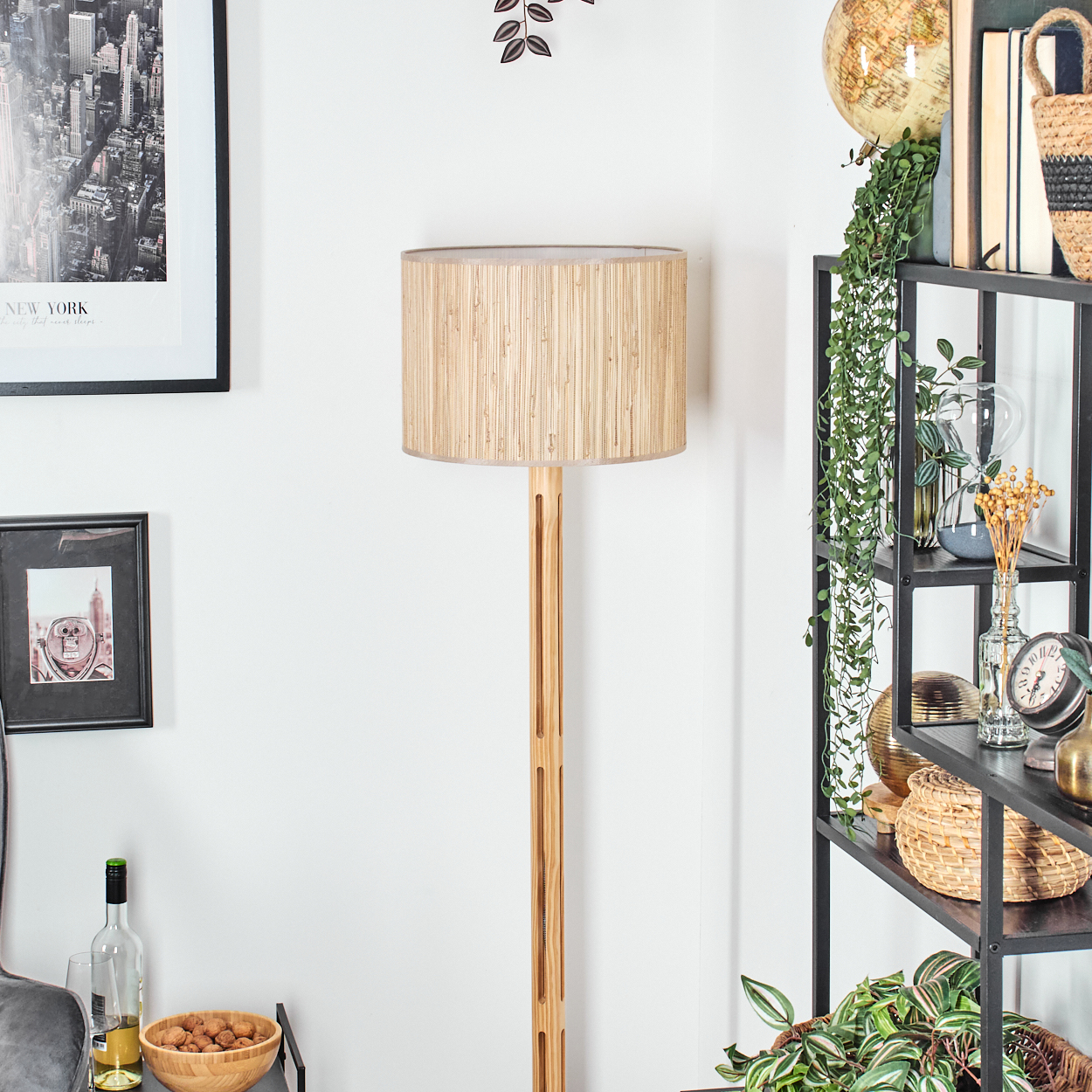 Ein Raum mit einer Holzlampe, Regalen mit Dekoration, einem New York-Bild und einer Schüssel mit Nüssen.
