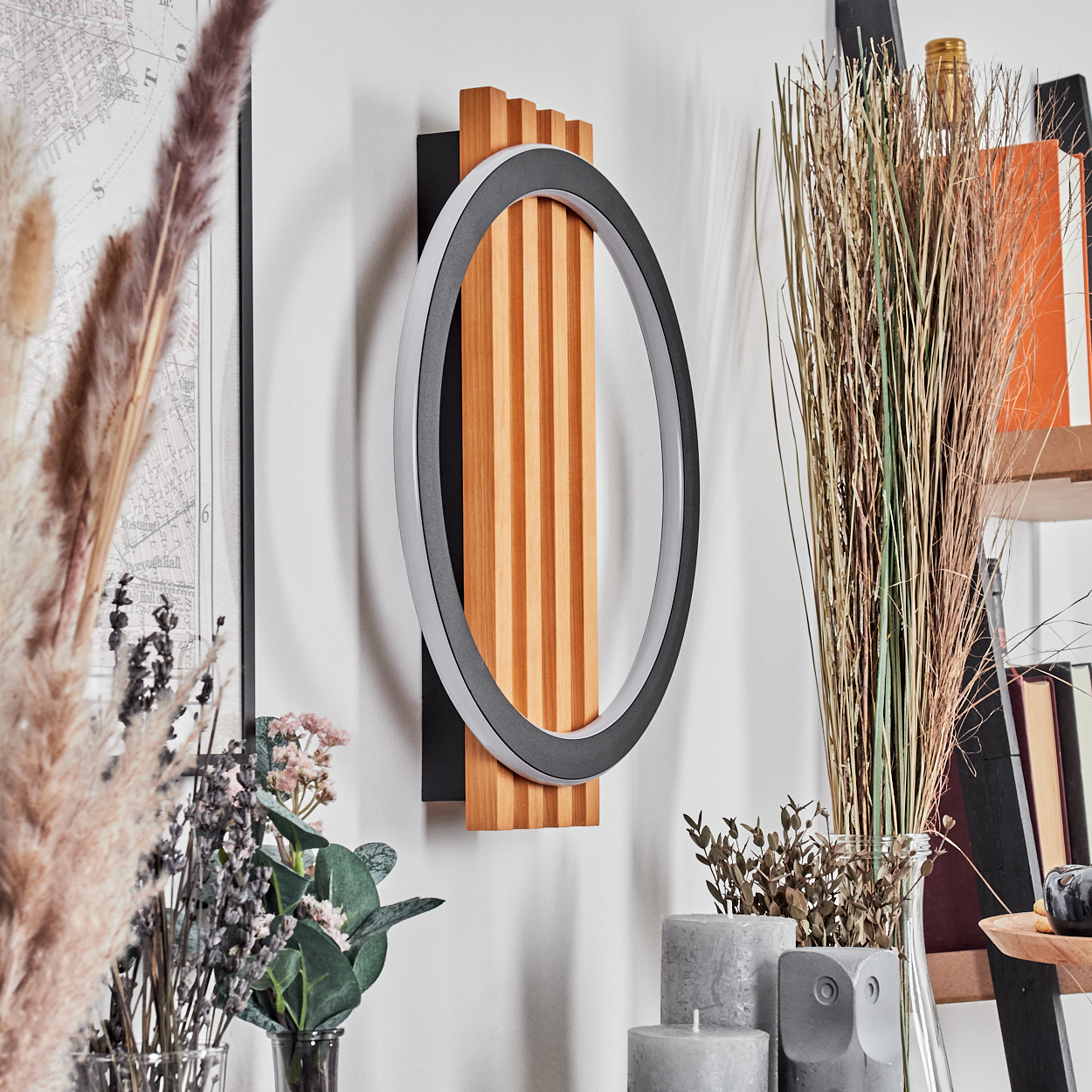 Eine moderne Wandleuchte mit kreisförmigem Licht und Holzpaneel. Trockenblumen und Kerzen schmücken die Szene.
