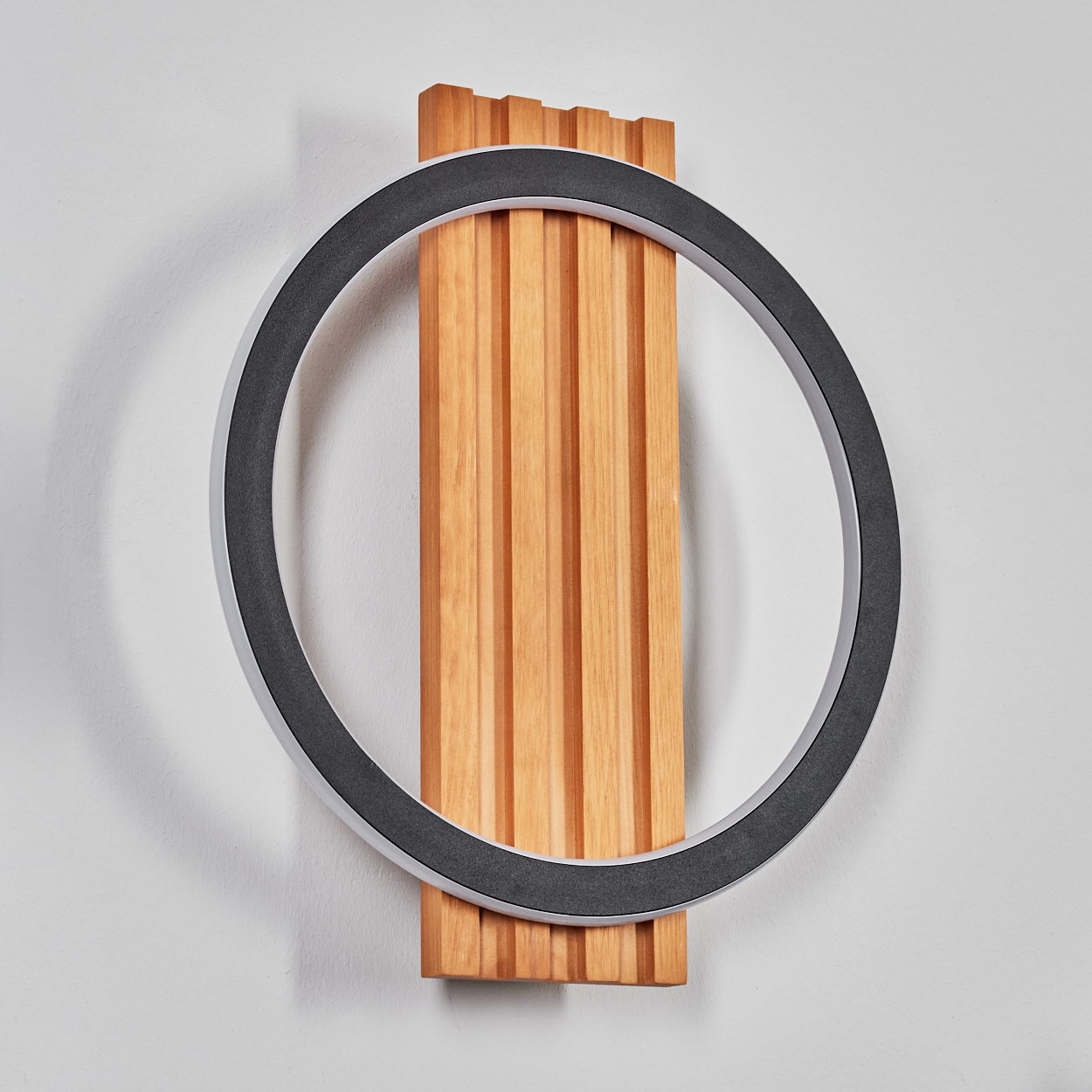 Moderne Wanddekoration. Sie besteht aus einer Holzverkleidung mit vertikalen Rillen und einem kreisförmigen Licht mit dunklem Rand.