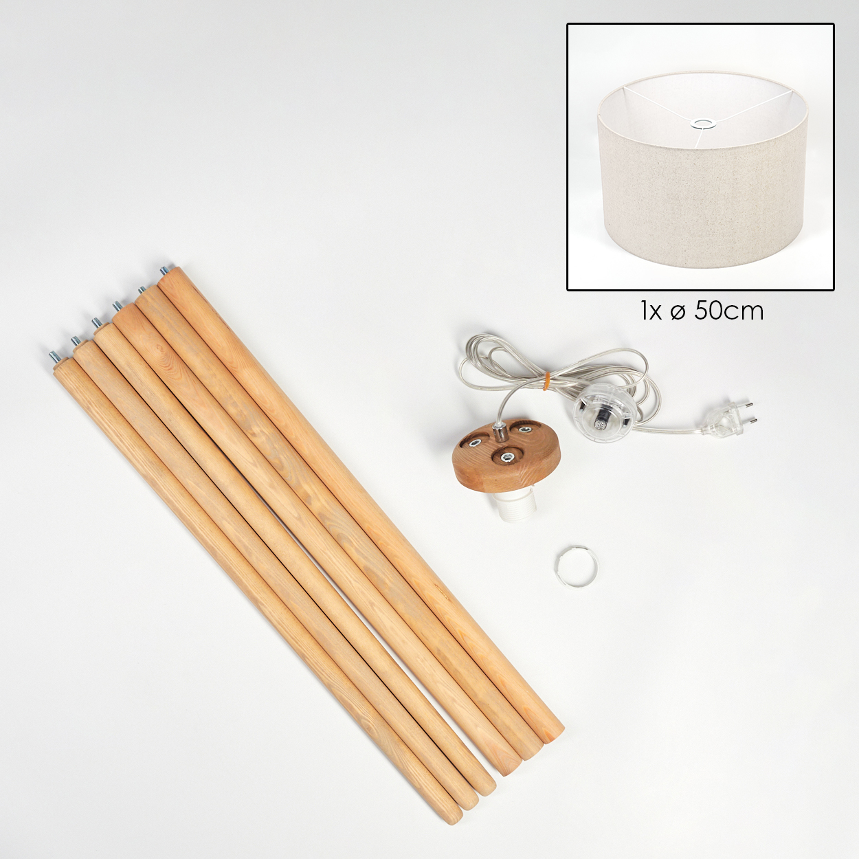 Ein zerlegtes Lampen-Kit auf weißer Oberfläche. Enthält Holzstangen, Lampenschirm, elektrische Komponenten und einen Ring.