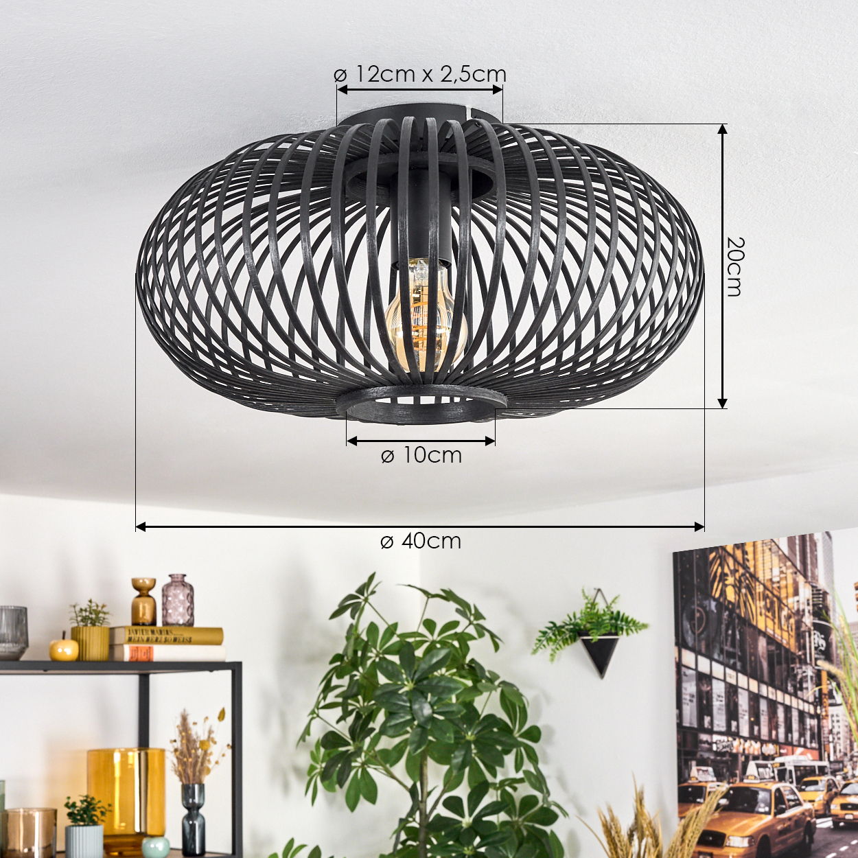 Eine schwarze, käfigartige Deckenlampe mit sichtbarer Glühbirne. Abmessungen sind angegeben. Im Hintergrund Pflanzen und Dekoration auf Regalen.