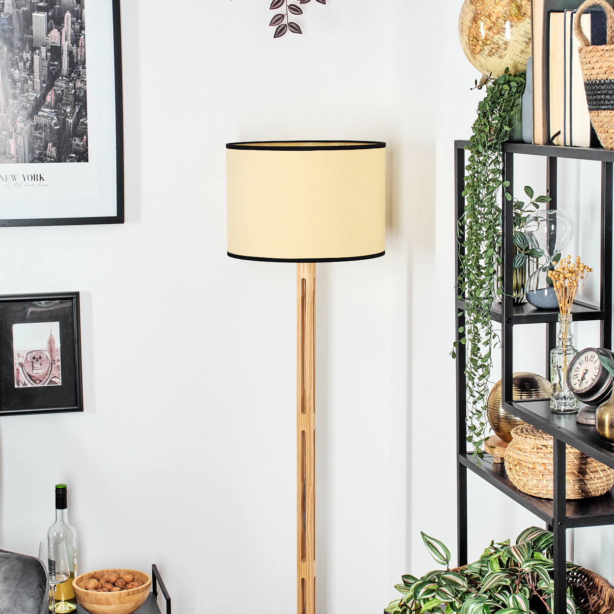 Ein Raum mit einer Holzlampe, einem New York-Bild, einem Regal mit Pflanzen und einer Schüssel mit Walnüssen.
