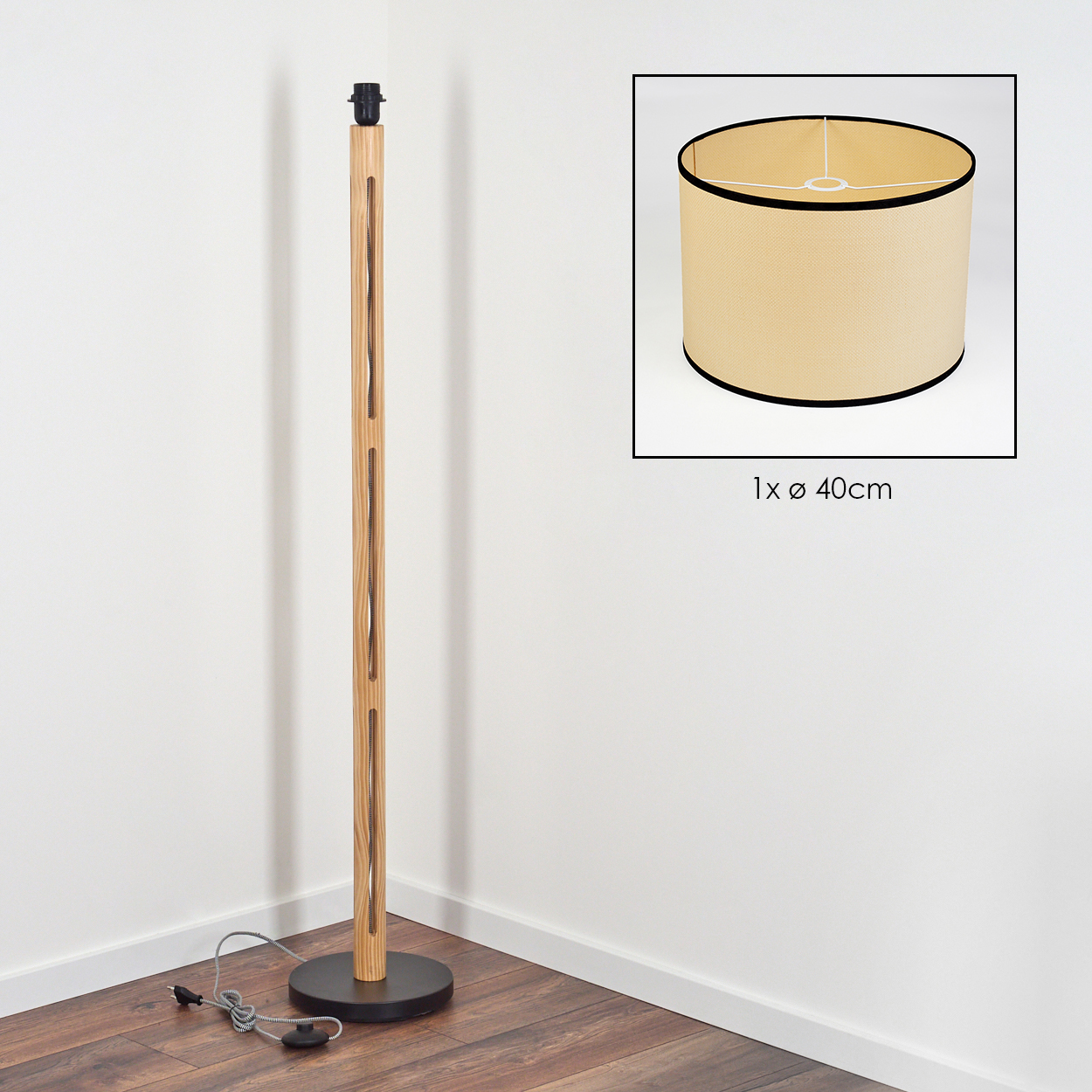 Eine Stehlampe aus Holz mit schwarzem Sockel und beigem Lampenschirm steht in der Ecke eines Raumes neben einer weißen Wand.