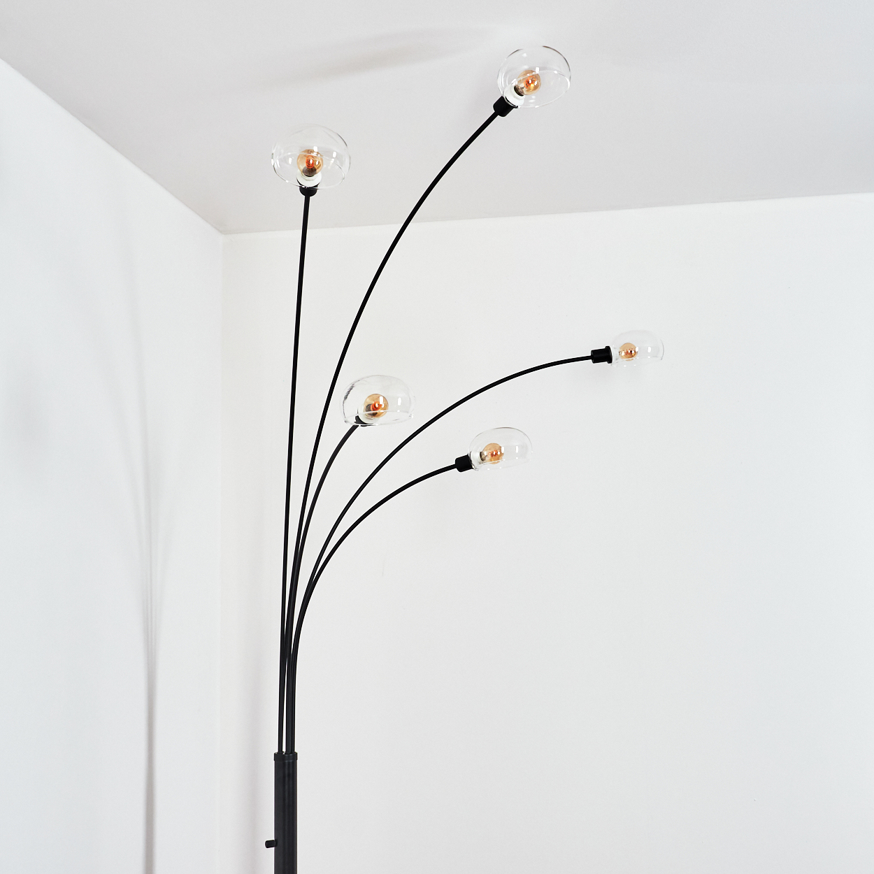 Eine moderne Stehlampe mit fünf Glühbirnen. Die Lampe hat einen schwarzen Stiel und gebogene Arme, die klare, kugelförmige Glühbirnen halten.