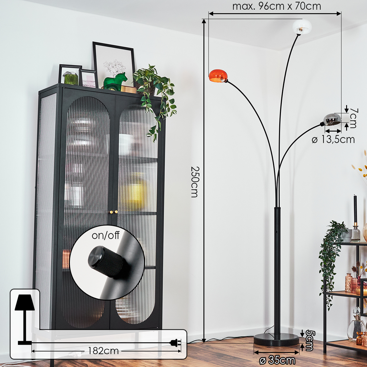 Ein modernes Zimmer mit einer schwarzen Stehlampe und einem schwarzen Schrank. Die Lampe hat drei Lichter, und der Schrank zeigt Gegenstände.