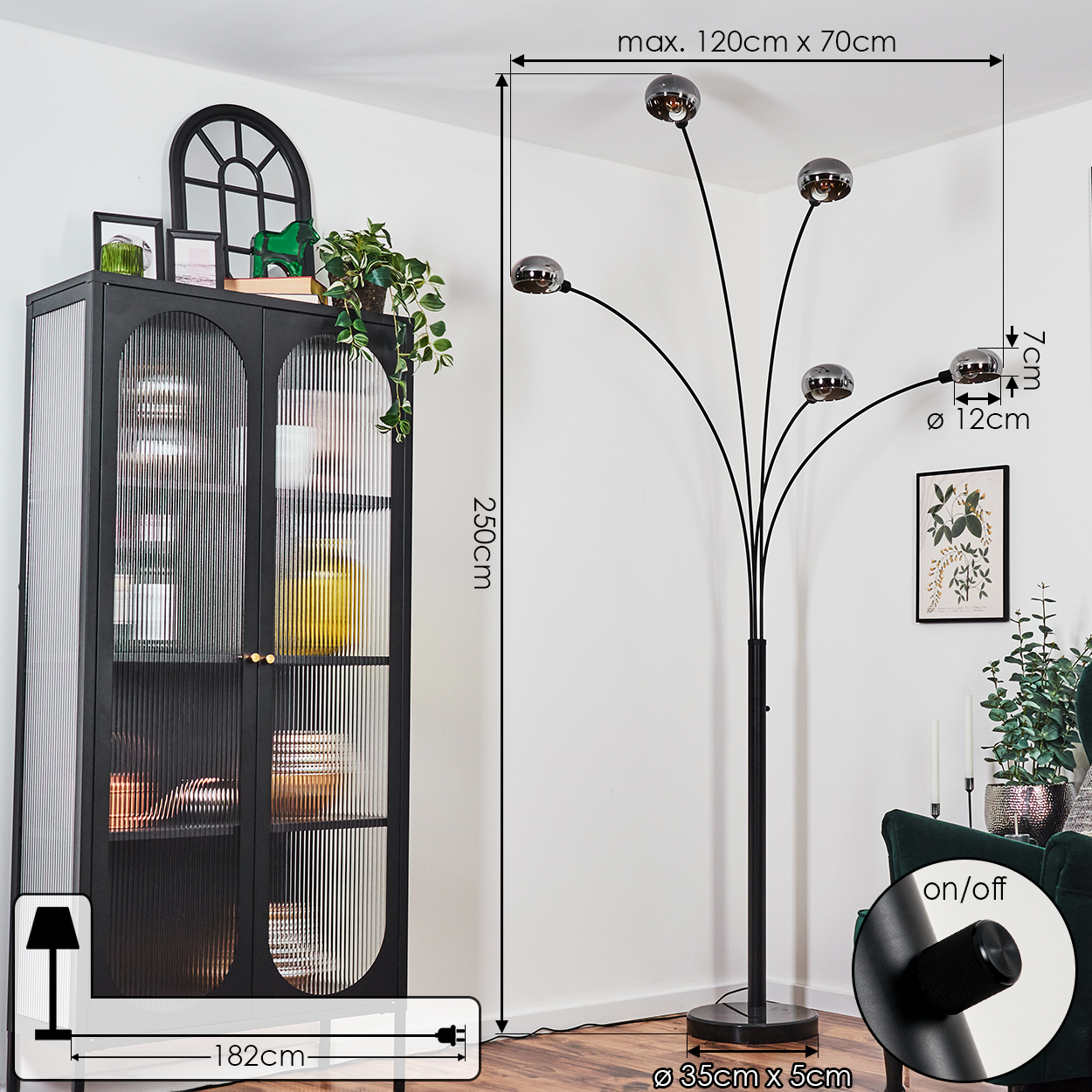 Moderne schwarze Stehlampe mit fünf kugelförmigen Lichtern. Links ein schwarzer Schrank mit Glastüren. Weiße Wand mit Maßen.