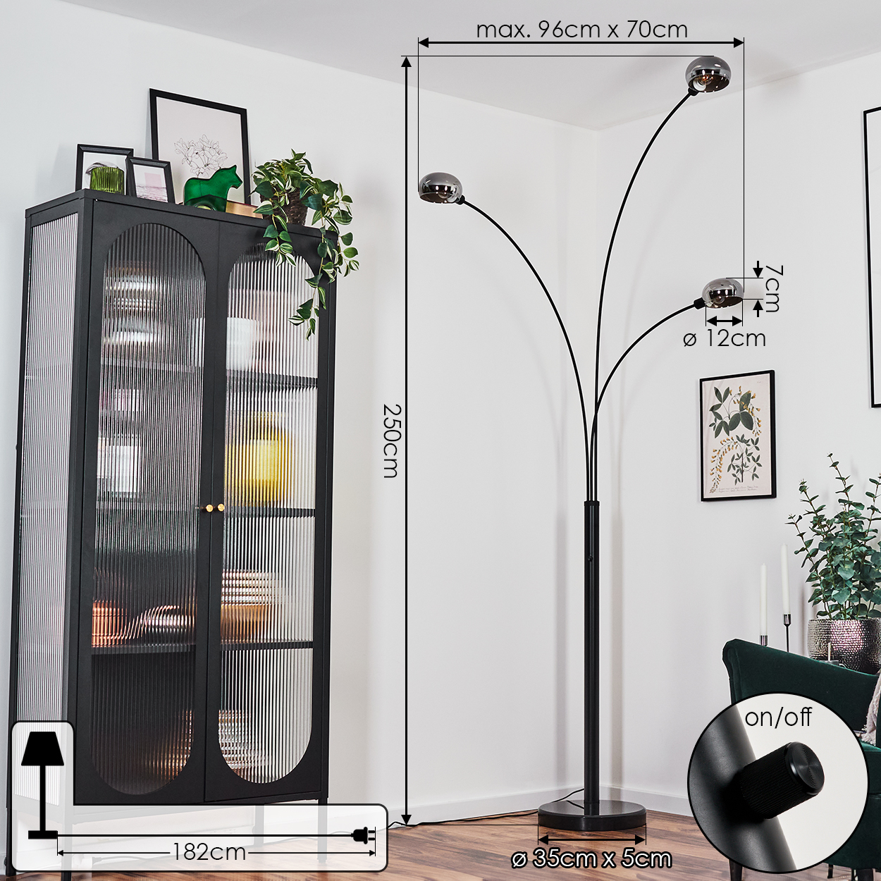 Ein modernes Wohnzimmer mit schwarzer Stehlampe, Schrank und grünem Sofa. Maße sind angegeben.