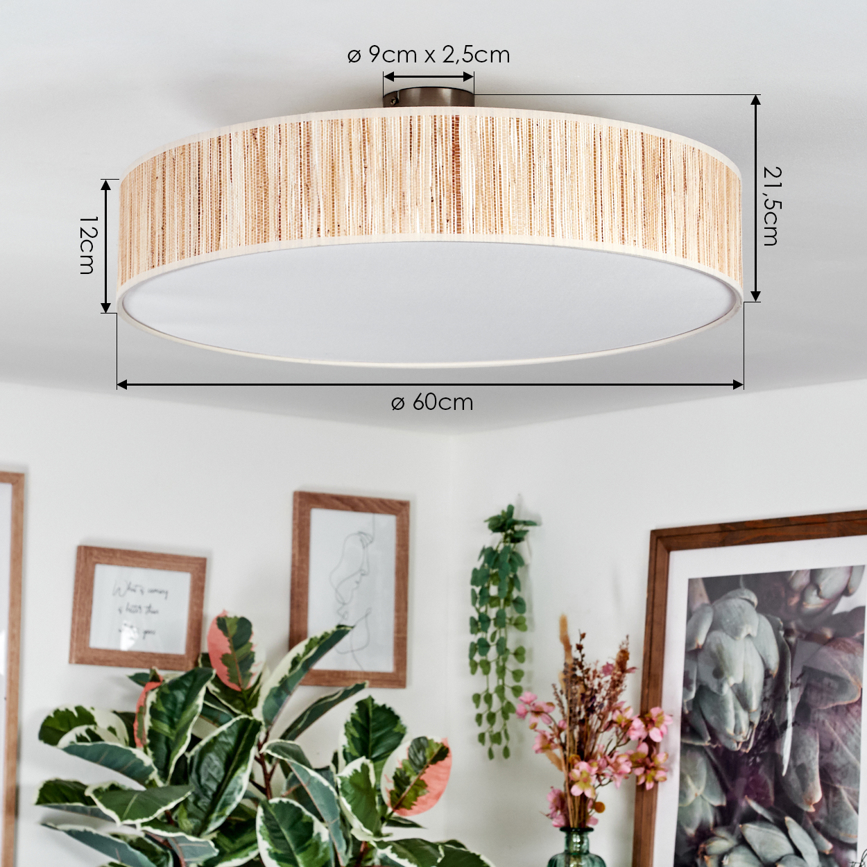 Eine runde Deckenlampe mit gewebtem Schirm. Darunter sind Pflanzen, Bilder und Dekorationen sichtbar, was eine gemütliche Atmosphäre schafft.