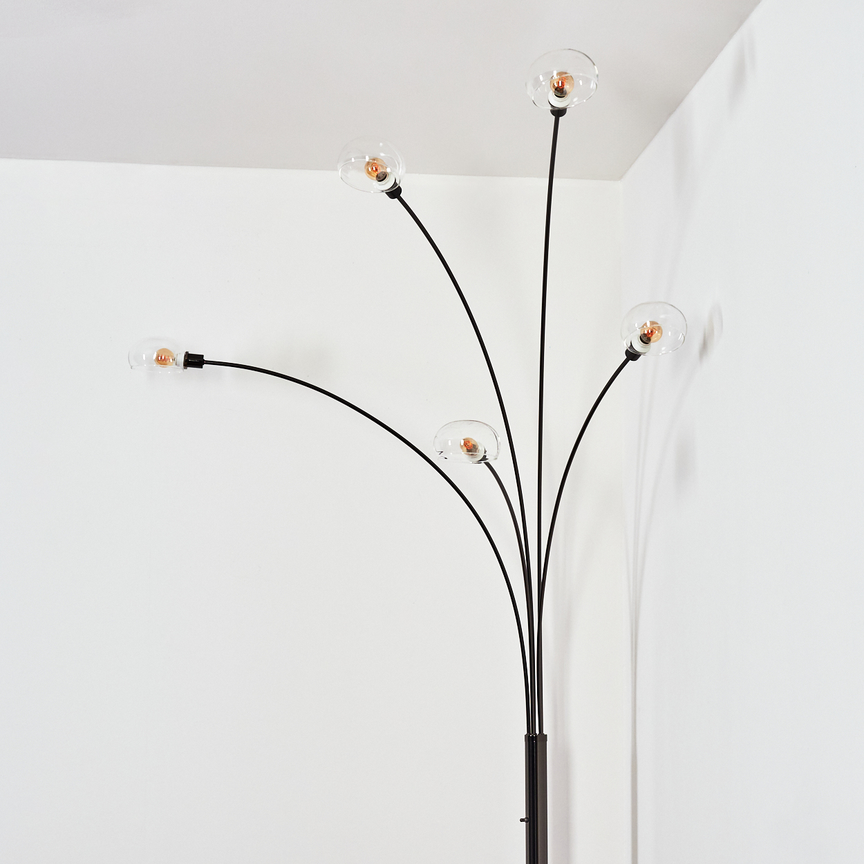 Eine moderne Stehlampe mit fünf gebogenen schwarzen Armen, die jeweils einen klaren Glaskolben mit Glühbirne halten. Der Hintergrund ist weiß.