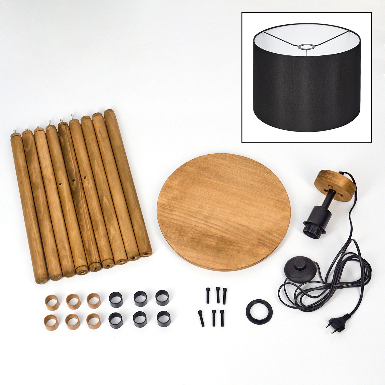 Zerlegte Lampenteile. Holzbeine, runde Basis, Lampenschirm, Lampenhalter, Schrauben und Ringe sind auf weißer Oberfläche angeordnet.
