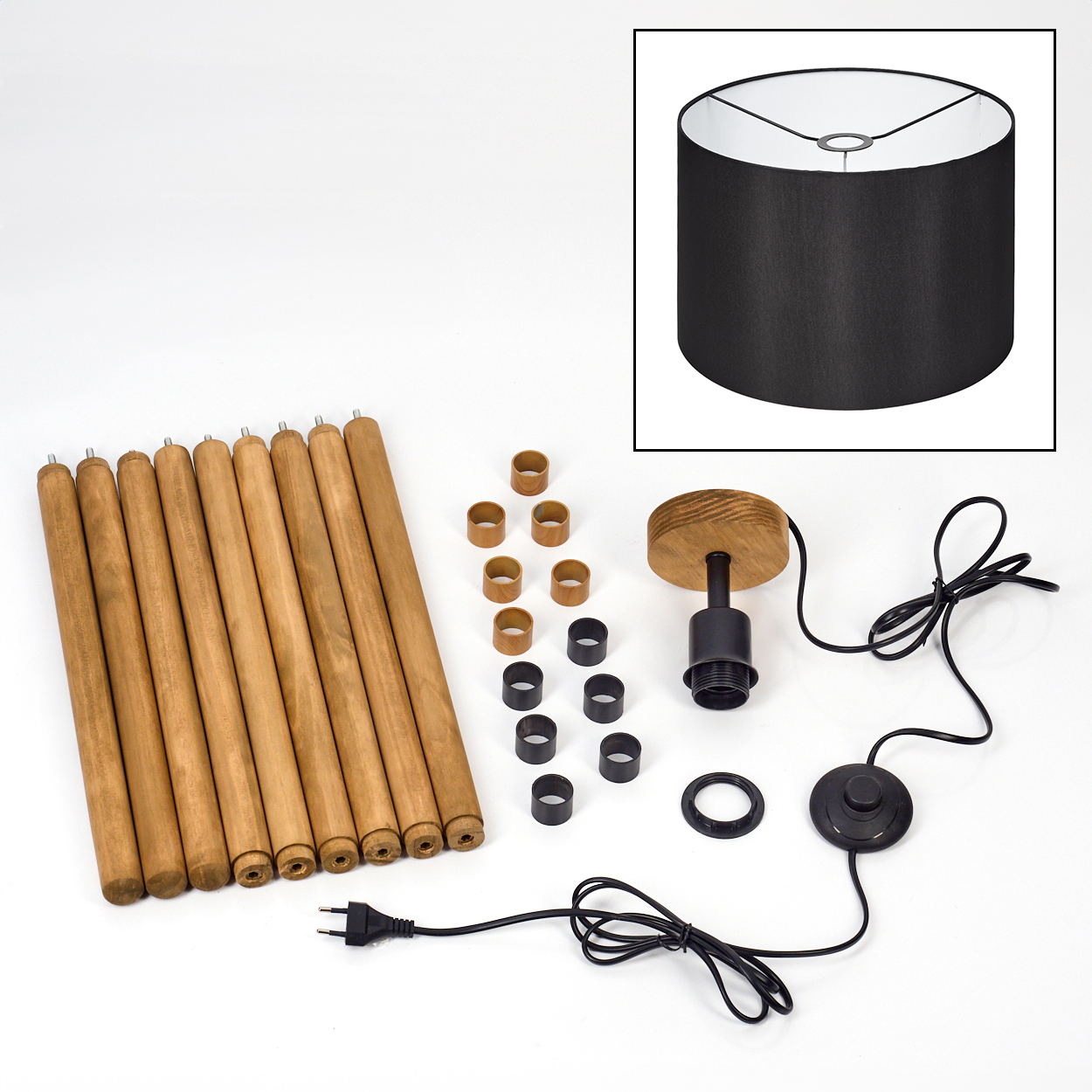 Zerlegte Lampenteile auf weißem Hintergrund. Enthält Holzbeine, Lampenschirm, elektrische Komponenten und Ringe.