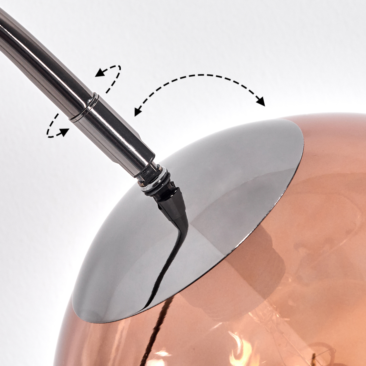Nahaufnahme einer modernen Lampe. Ein silberner Metallarm erstreckt sich in eine kupferfarbene Kugel mit silberner Kappe. Gepunktete Pfeile zeigen Bewegung an.