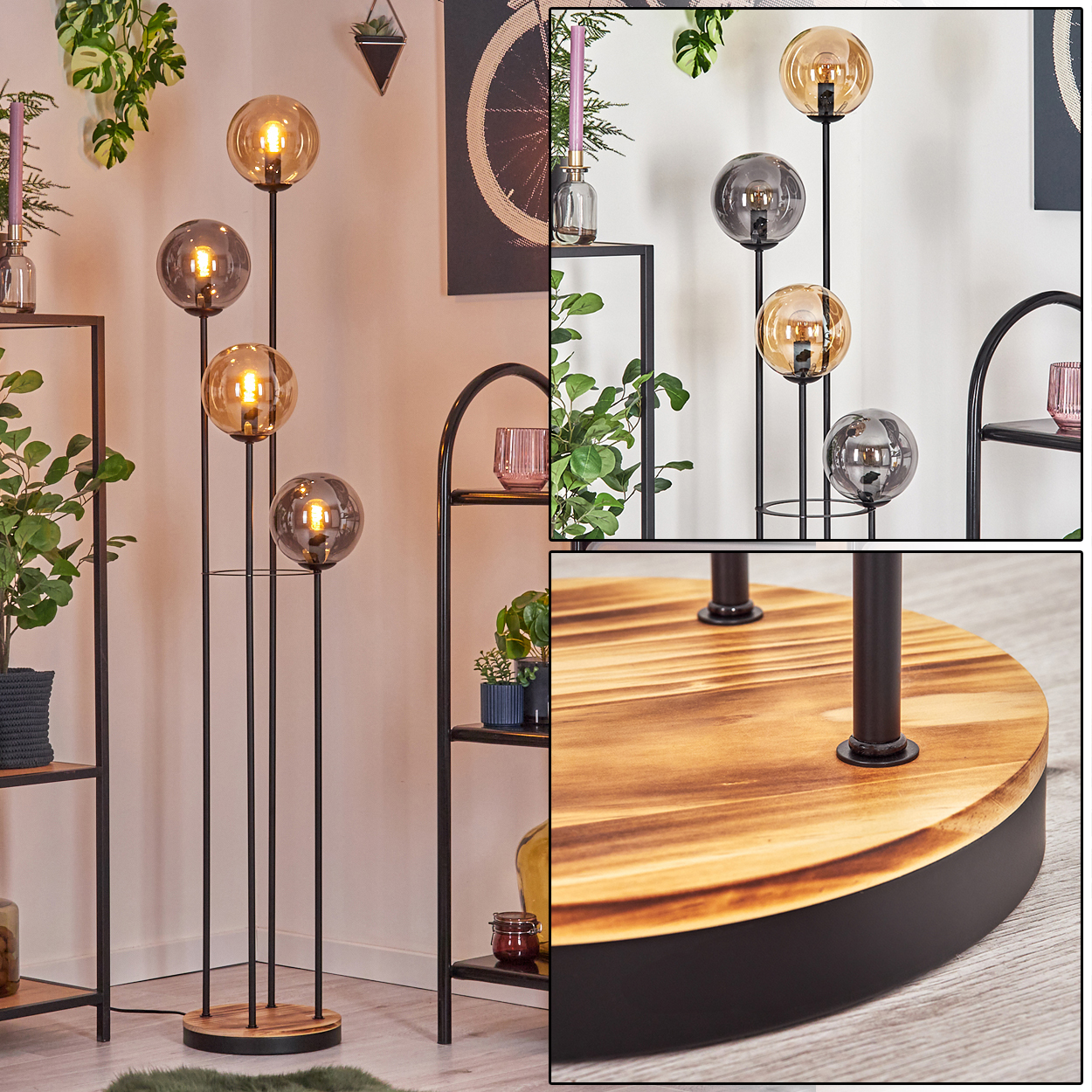 Eine moderne Stehlampe mit vier Glaskugeln. Sie steht auf einem Holzsockel mit schwarzem Metallrahmen. Im Hintergrund sind Regale und Pflanzen.