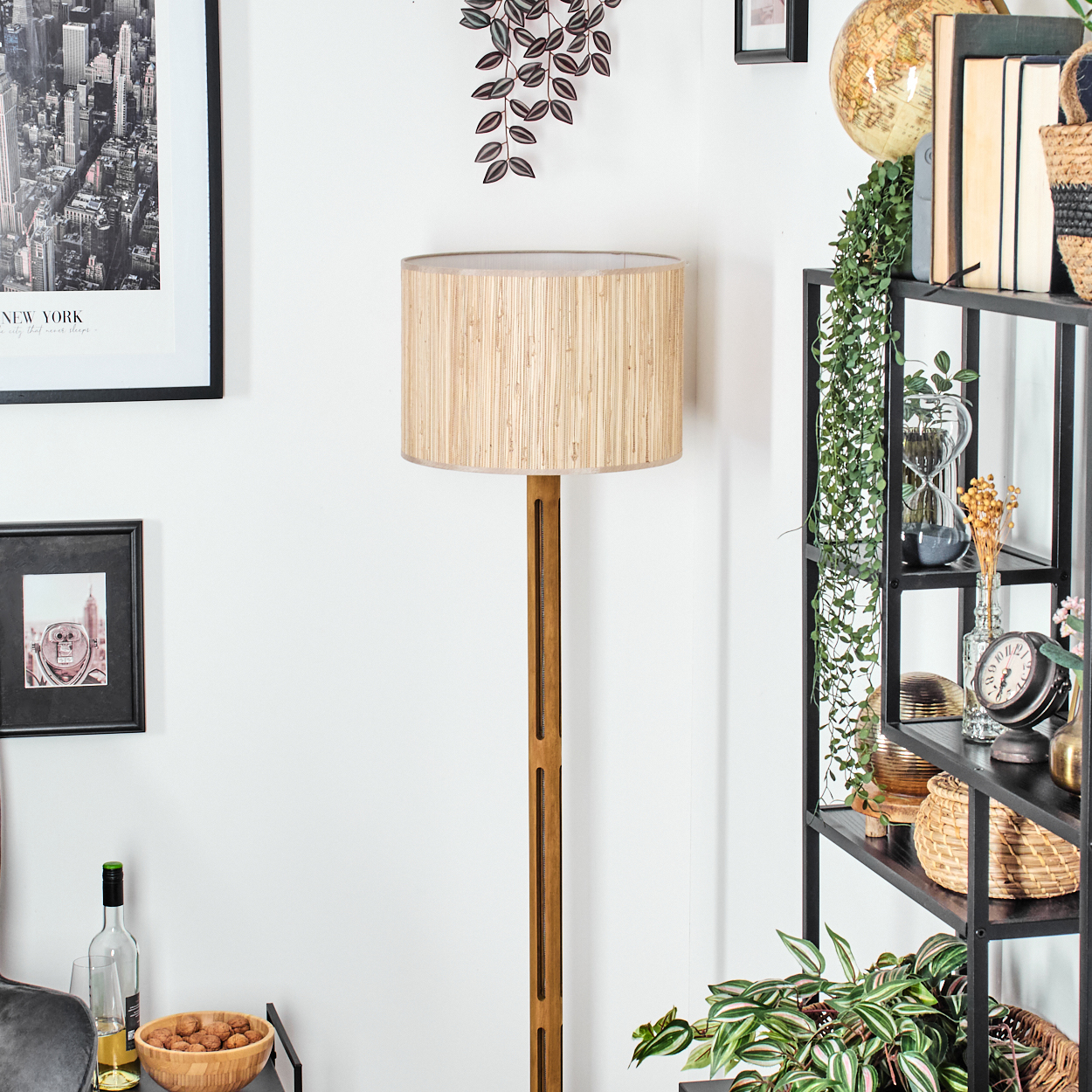 Ein Raum mit einer Holzlampe, einem schwarzen Regal mit Dekorationen und einem New York-Bilderrahmen.