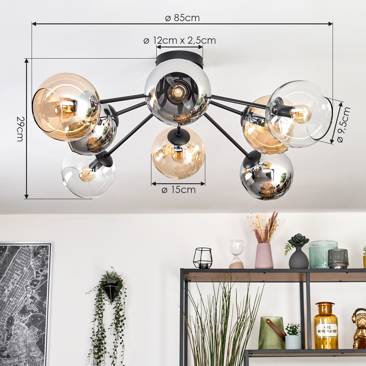 Eine moderne Deckenlampe mit mehreren Glaskugeln. Sie hat schwarze Arme und eine Chrommitte. Maße sind angegeben.