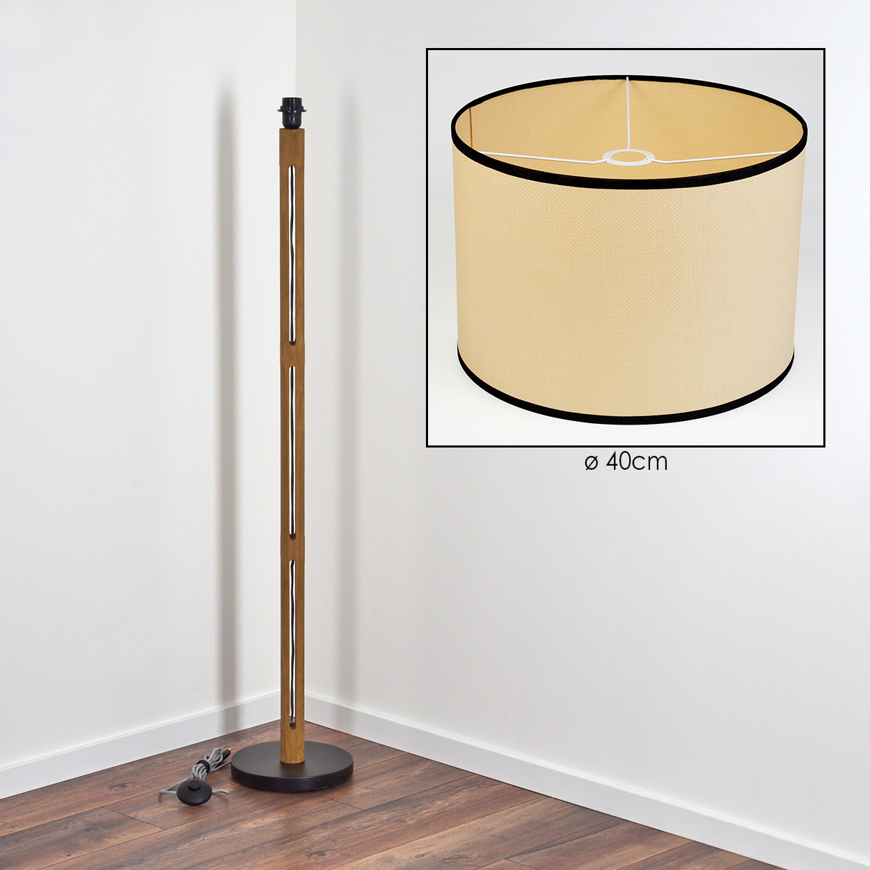 Stehlampe aus Holz mit beigem Lampenschirm, schwarzen Rändern und rundem Sockel. Der Lampenschirm hat einen Durchmesser von 40 cm. Der Hintergrund ist weiß.
