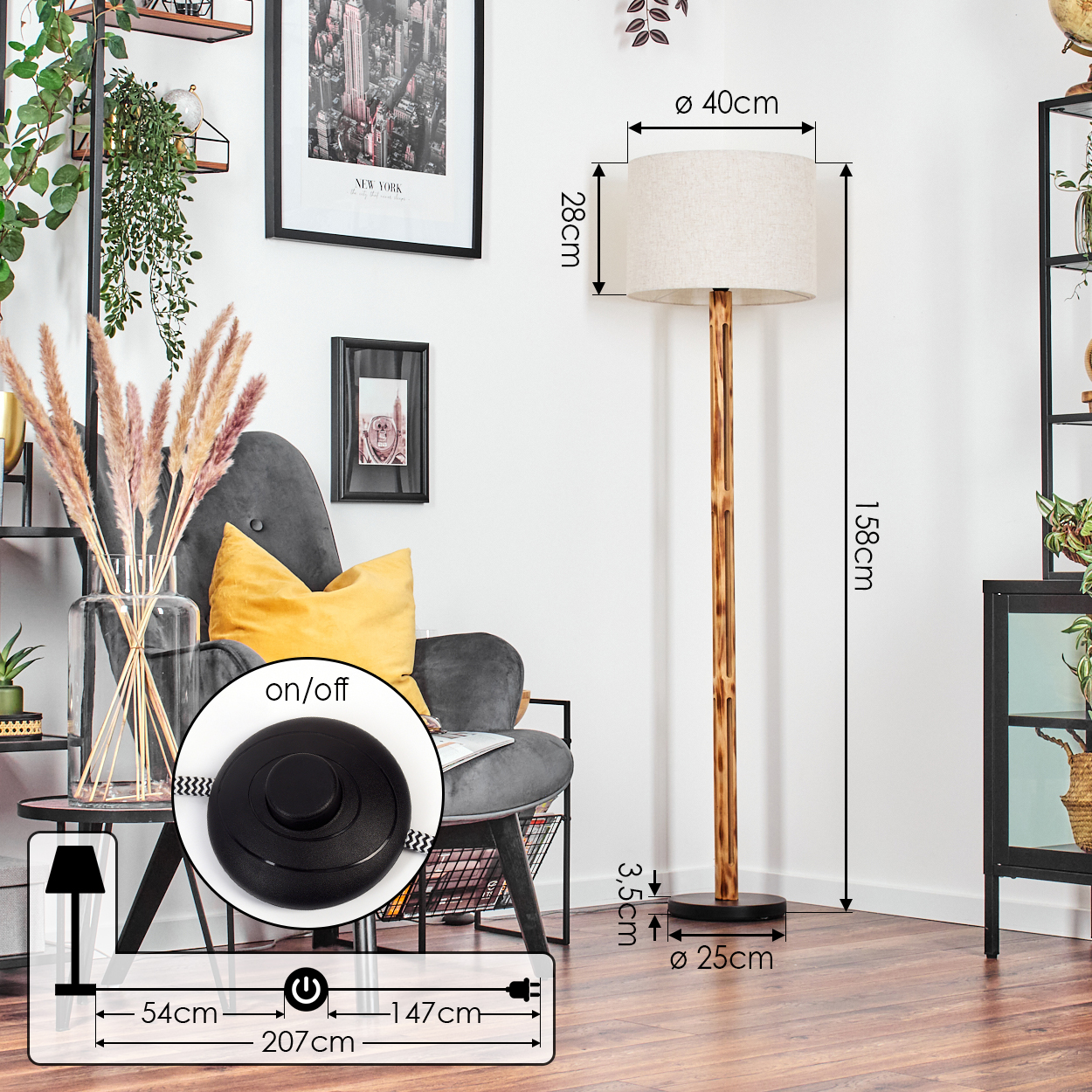 Eine Stehlampe mit beigem Schirm und Holzstange steht neben einem grauen Sessel mit gelbem Kissen. Ein New York-Bild hängt an der Wand.