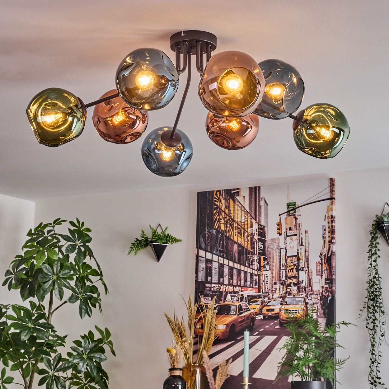 Deckenlampe mit Glaskugeln, ein Stadtbildgemälde und Pflanzen. Das Licht hat bernsteinfarbenes und grünes Glas. Gemälde zeigt Taxis.