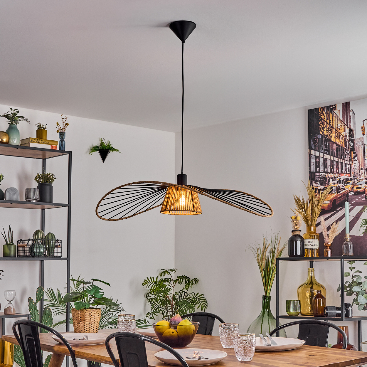 Esszimmer mit Holztisch, schwarzen Stühlen, einzigartiger Leuchte und Dekoration auf Regalen. Ein Stadtbildgemälde an der Wand.