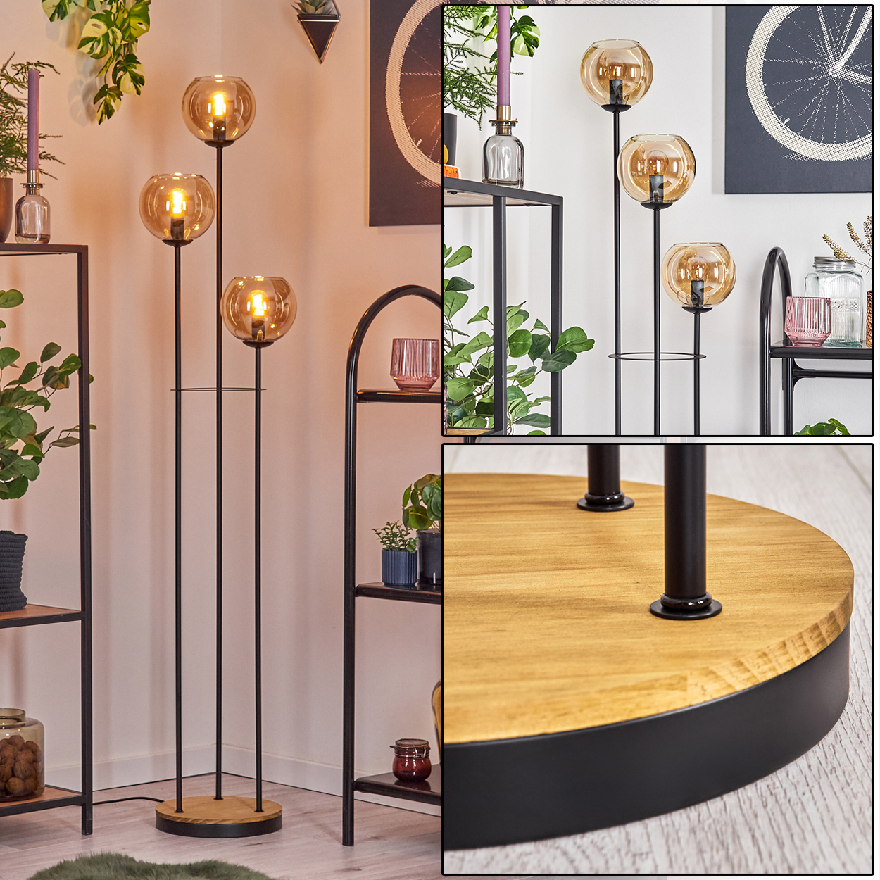Eine Stehlampe mit drei Kugelleuchten. Sie steht auf einem Holzsockel mit schwarzen Metallstützen. Regale mit Pflanzen im Hintergrund.