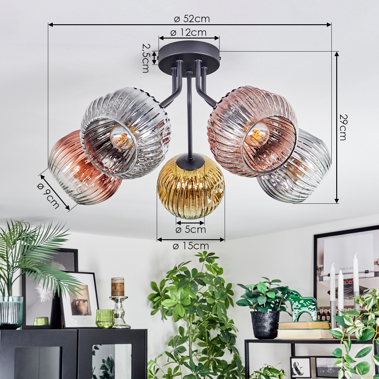 Deckenlampe mit fünf Glaskugeln in verschiedenen Farben, mit Maßangaben. Pflanzen und Möbel im Hintergrund.