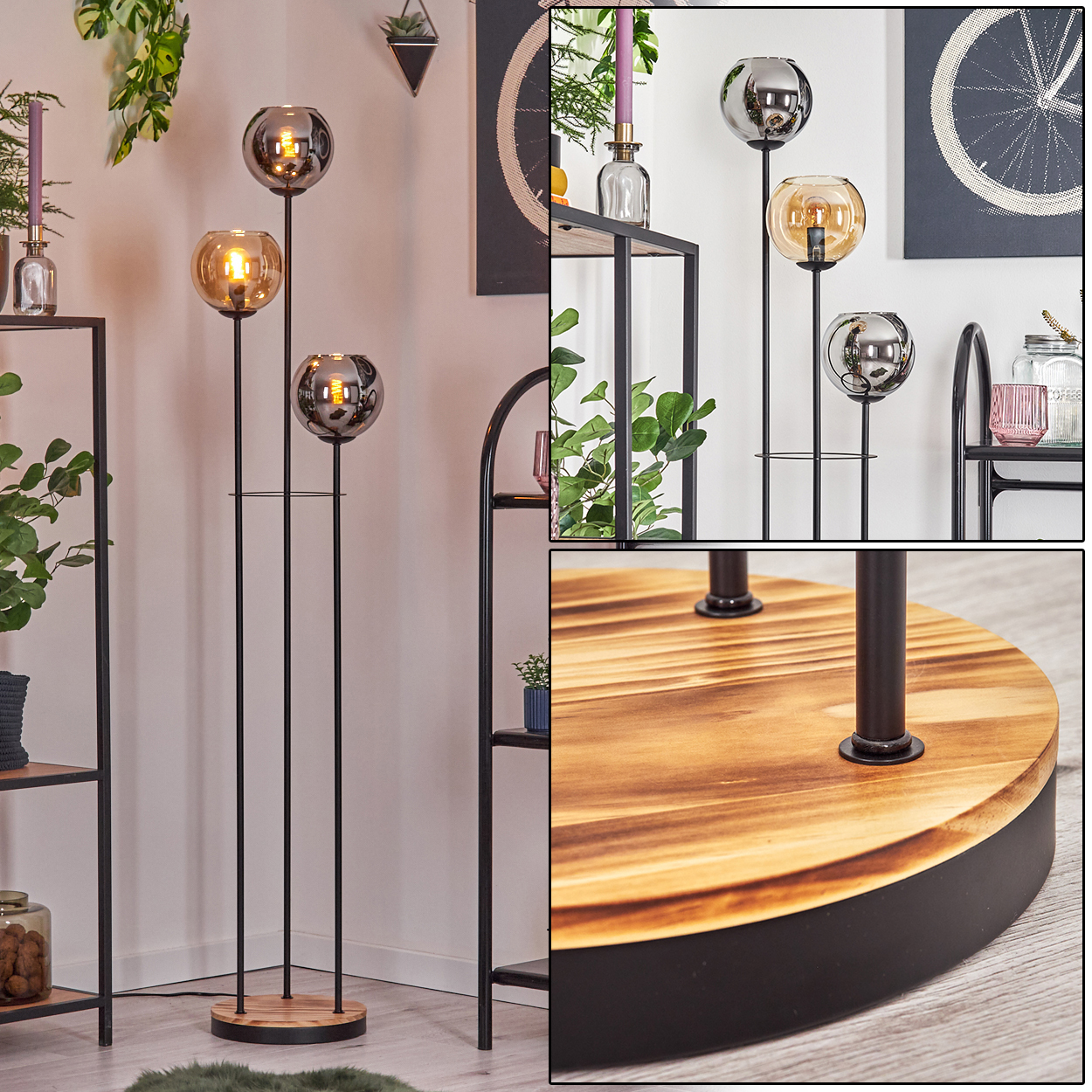Stehlampe mit drei Glaskugeln. Sie hat einen Holzsockel und ein schwarzes Metallgestell. Regale und Pflanzen befinden sich im Hintergrund.