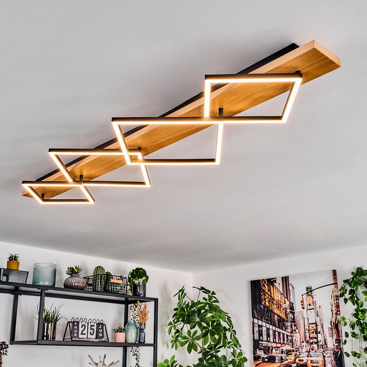 Moderne Deckenleuchte mit geometrischen Formen. Darunter ein Regal mit Pflanzen und ein Bild von New York City.