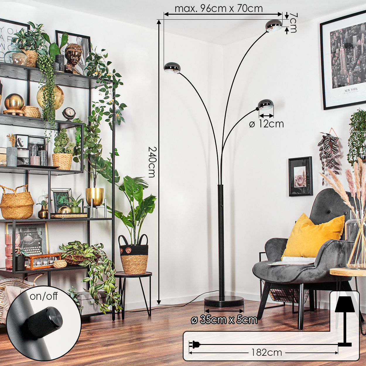 Ein modernes Wohnzimmer mit schwarzer Stehlampe, grauem Sessel und einem Metallregal mit Pflanzen und Dekorationen.