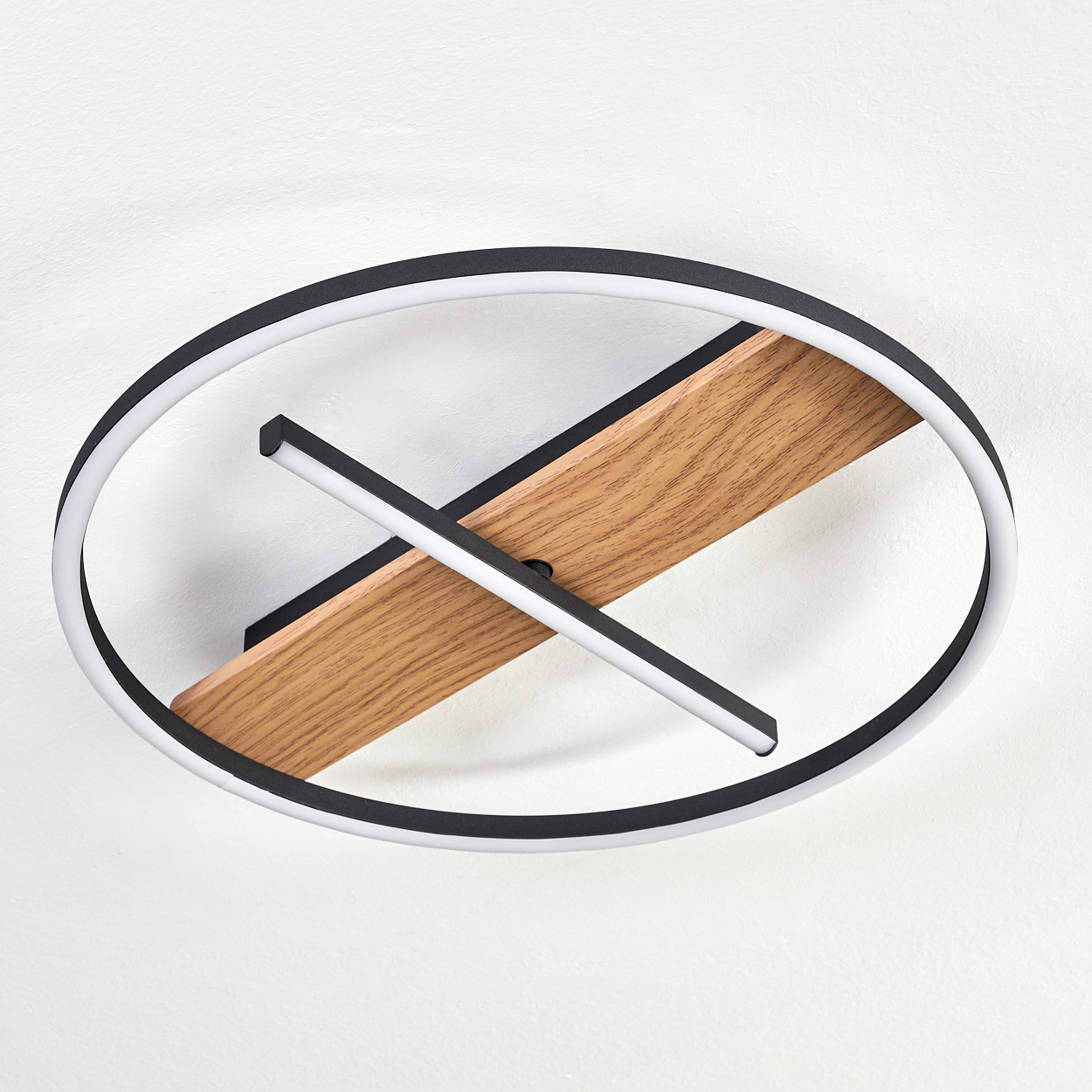 Deckenleuchte mit schwarz-weißem Kreisdesign. Enthält ein Holzbrett und einen weißen Lichtbalken, der es kreuzt.