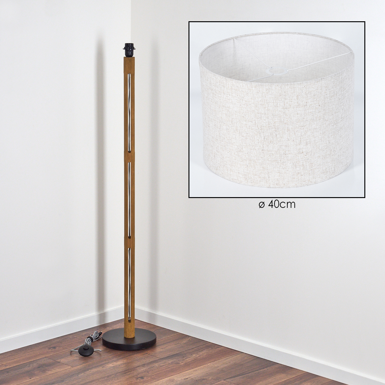 Eine Stehlampe aus Holz mit Lampenschirm. Der Lampenschirm ist zylindrisch, die Lampe hat einen runden Fuß. Der Hintergrund ist eine weiße Ecke.