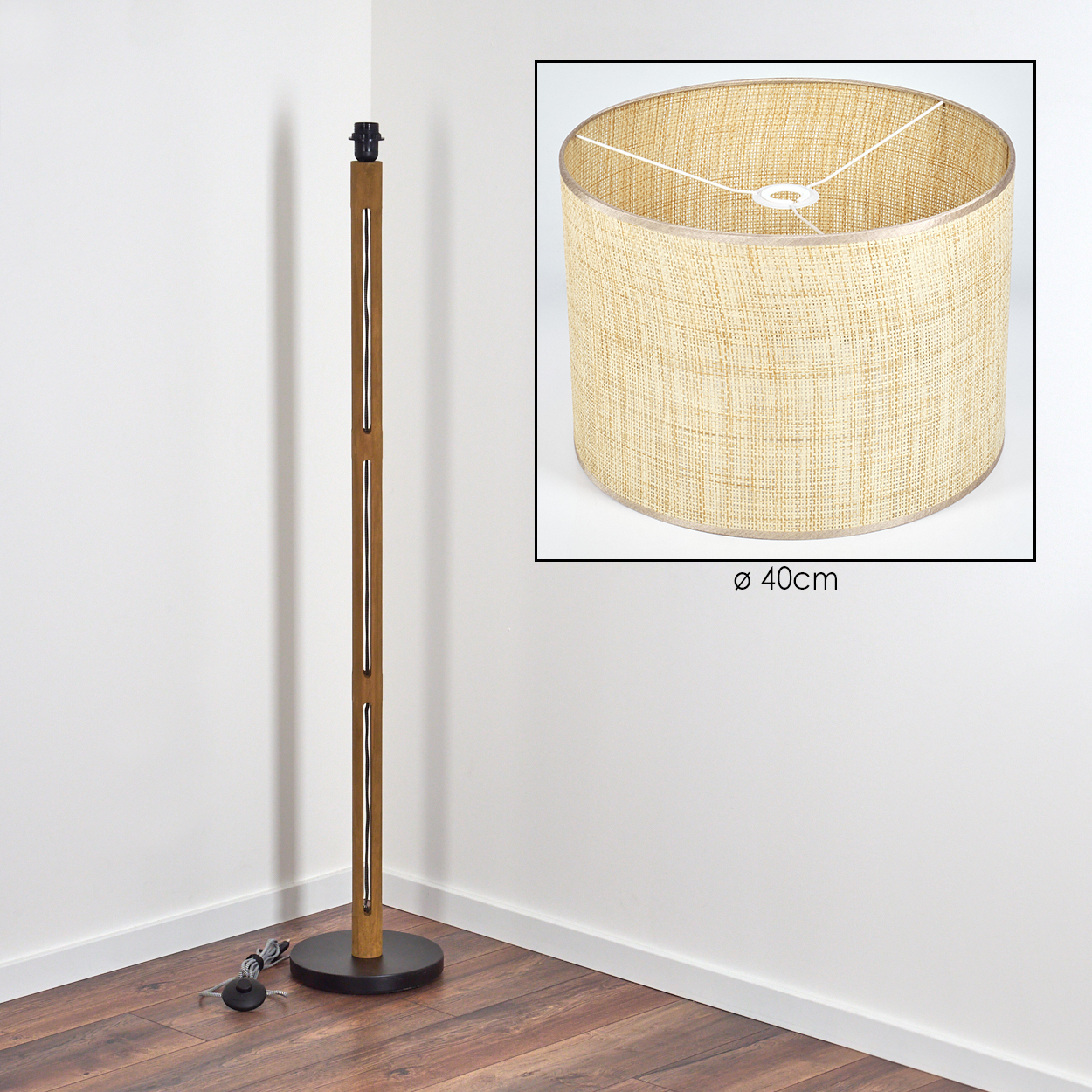Eine Stehlampe aus Holz mit Lampenschirm. Der Lampenschirm ist zylindrisch, beige und hat einen Durchmesser von 40 cm. Die Lampe steht in einer Ecke.
