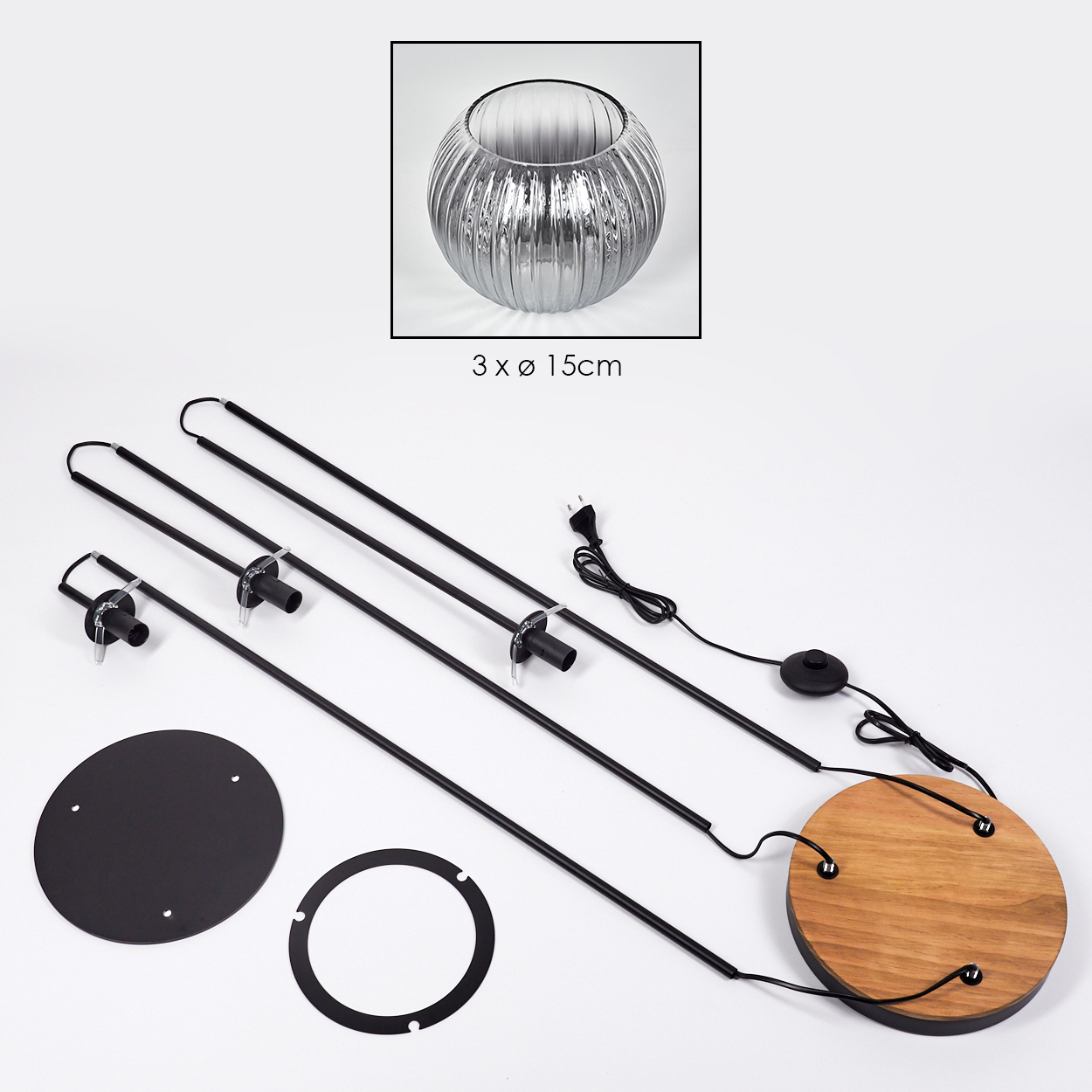 Zerlegte Lampenkomponenten auf Weiß. Enthält Glasschale, schwarze Metallstangen, Holzsockel und kreisförmige Metallteile.
