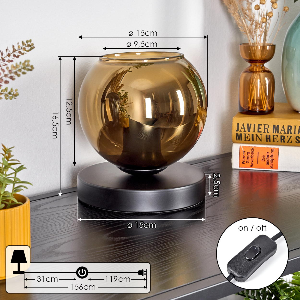 Eine dekorative Lampe mit einem goldenen Glaskugel steht auf einer schwarzen Oberfläche. Ein Schalter und Abmessungen sind gezeigt.
