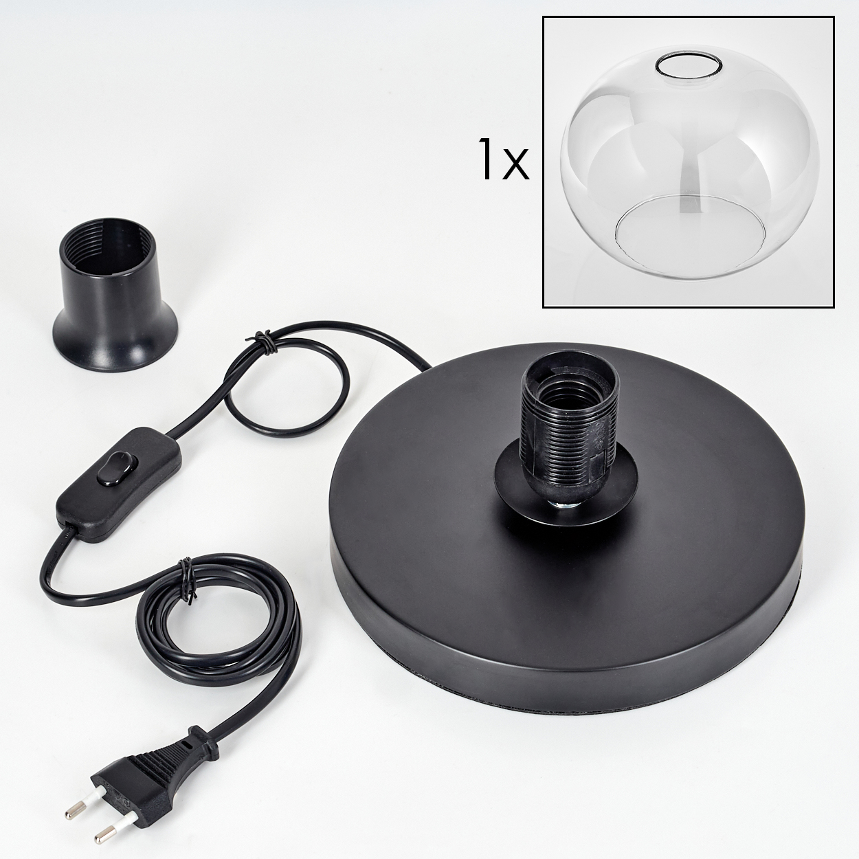 Eine zerlegte schwarze Pendelleuchte mit Glasschirm, Kabel, Stecker, Schalter und Sockel auf weißer Oberfläche.