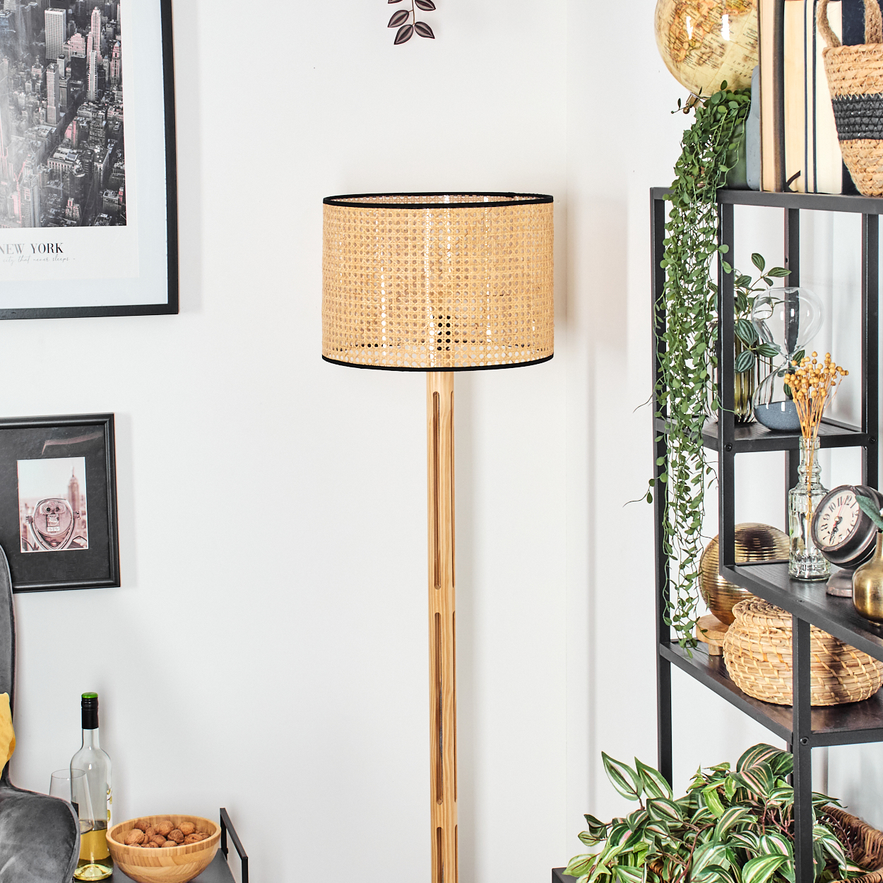 Ein Raum mit einer Holzlampe, einem New York-Bild, einem Regal mit Pflanzen und Dekorationen und einer Holzschüssel mit Nüssen.