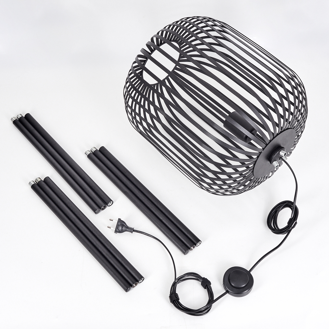 Schwarze zerlegte Lampe auf weißem Hintergrund. Teile umfassen Schirm, Standstücke, Draht mit Stecker und Fußschalter.