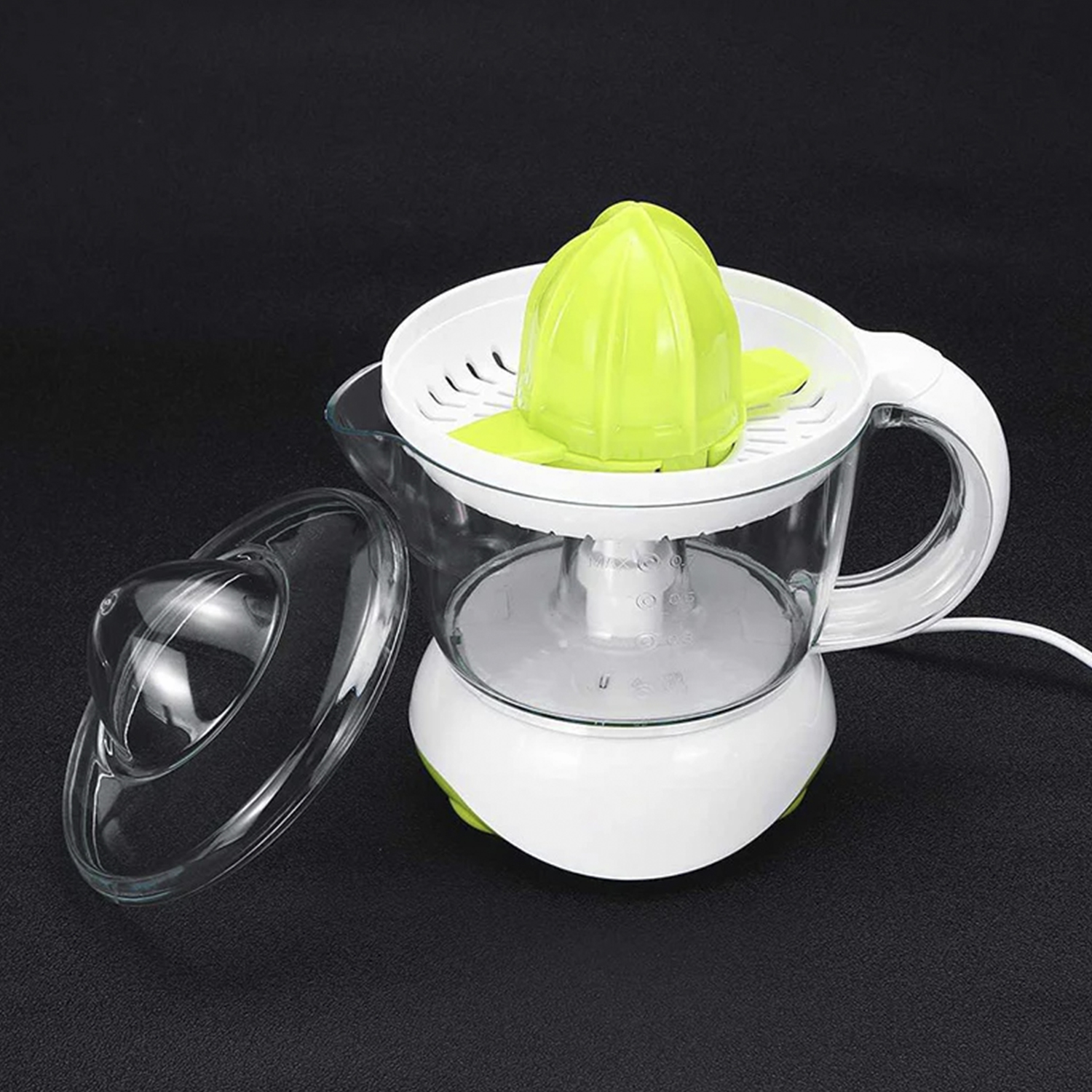 Uno spremiagrumi elettrico bianco e verde con una brocca e un coperchio in vetro trasparente. Lo spremiagrumi è su una superficie nera.