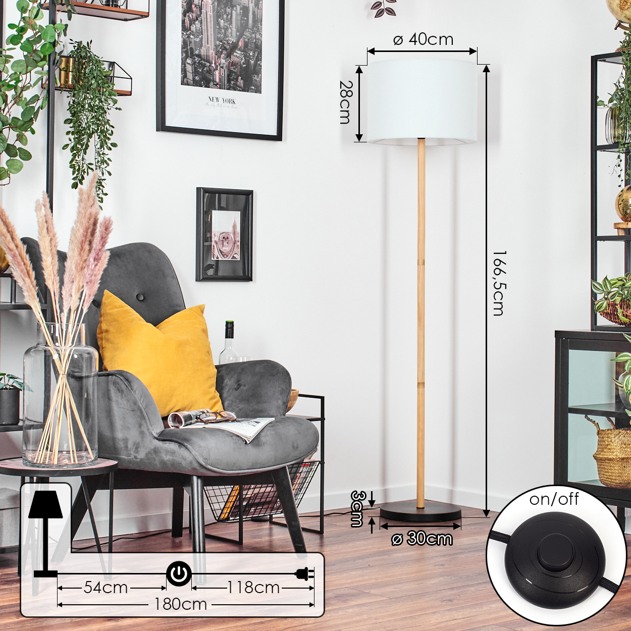 Ein Raum mit grauem Sessel, Stehlampe und schwarzem Rahmen mit New-York-Bild.