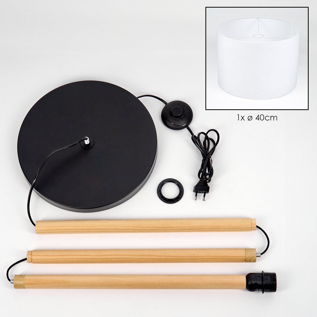 Zerlegte Lampe. Komponenten sind: schwarze Basis, Holzstangen, Lampenschirm, elektrische Teile und eine Lampenfassung.