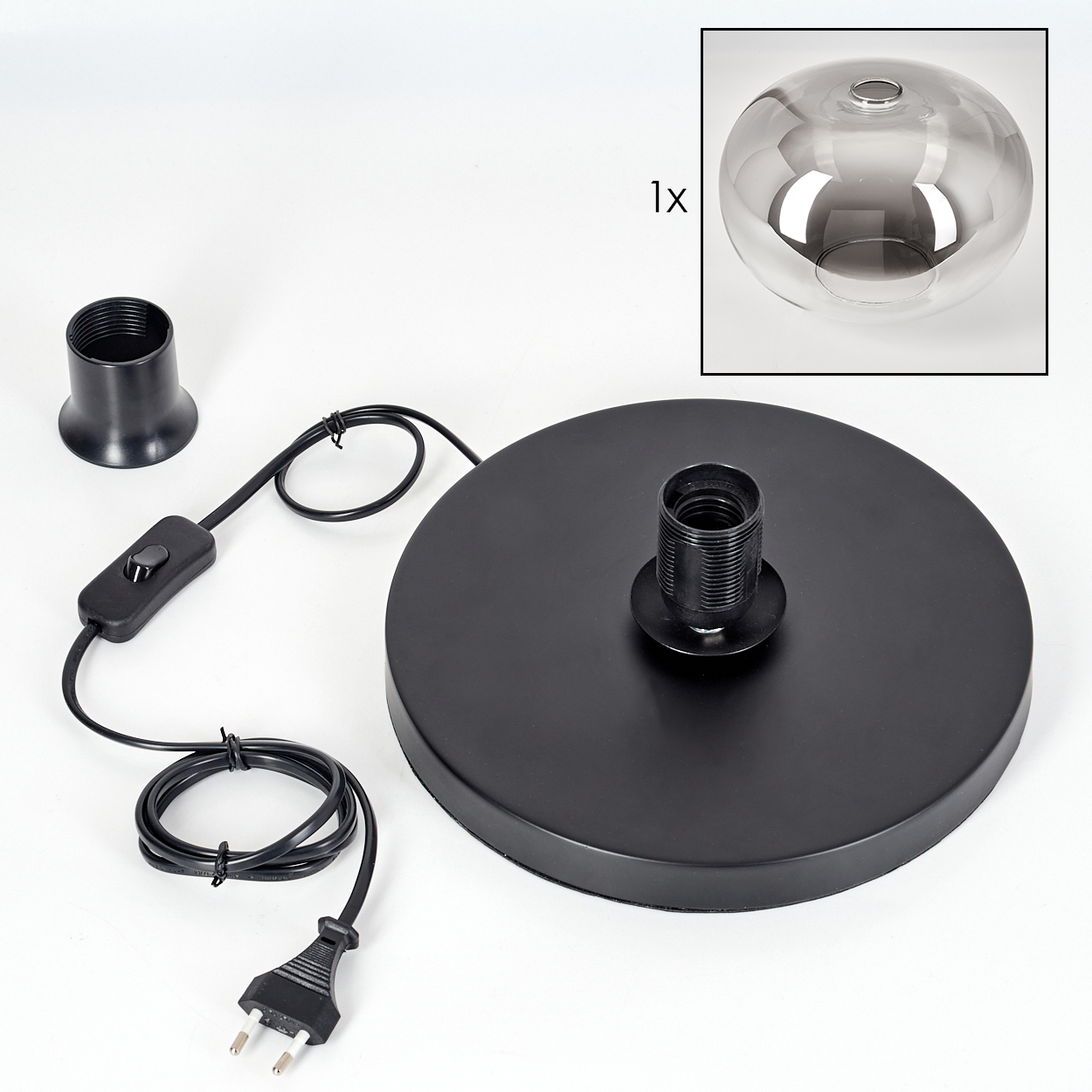 Zerlegte schwarze Lampe mit rundem Sockel, Fassung, Schalter und Netzkabel. Ein Glasschirm befindet sich in der Ecke.