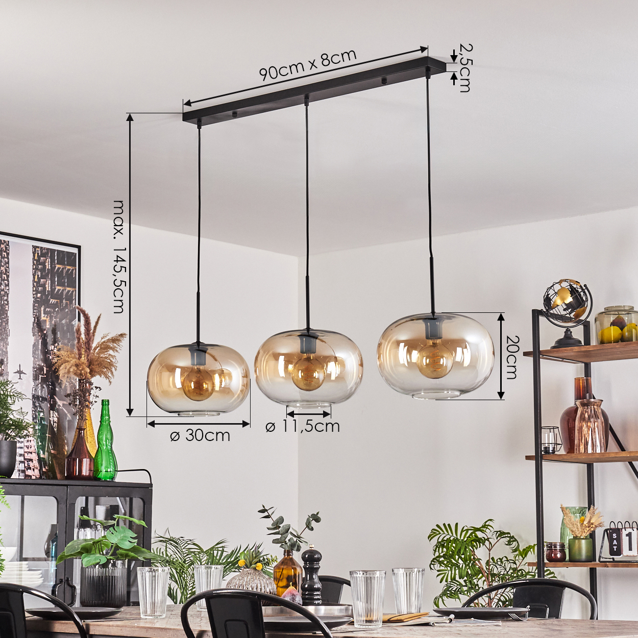 Drei Pendelleuchten mit bernsteinfarbenen Glasschirmen hängen über einem Holztisch. Der Raum hat einen Essbereich mit Pflanzen und Dekorationen.